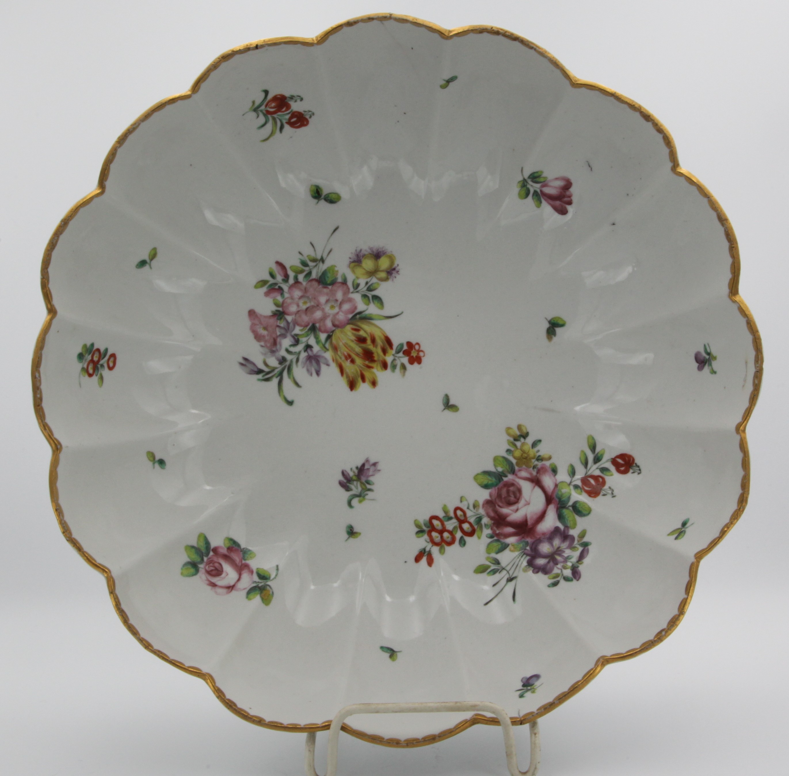 A large Bristol fluted junket dish, finely painted in coloured enamels with sprays of flowers and leaves, the lobed border with gilt dentil rim, blue painted X and gilt 3 marks.