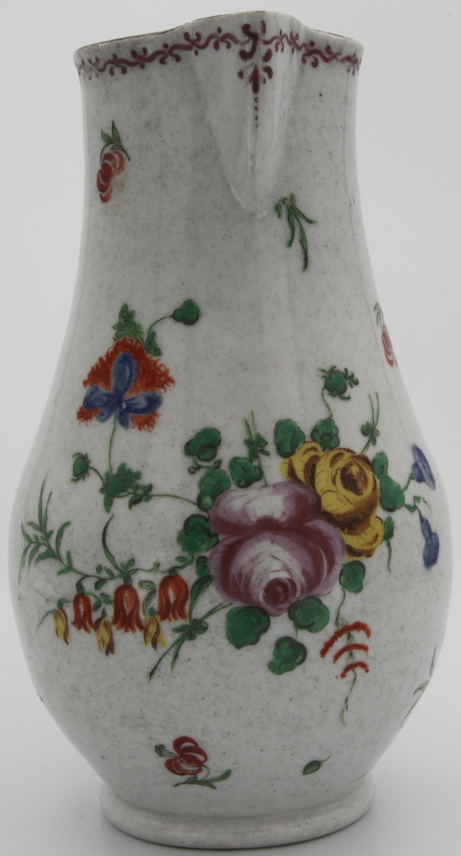 A Plymouth baluster jug with sparrow beak spout and grooved strap handle, painted with a loose bouquet of flowers and scattered sprays, iron-red tin mark, circa 1768-70