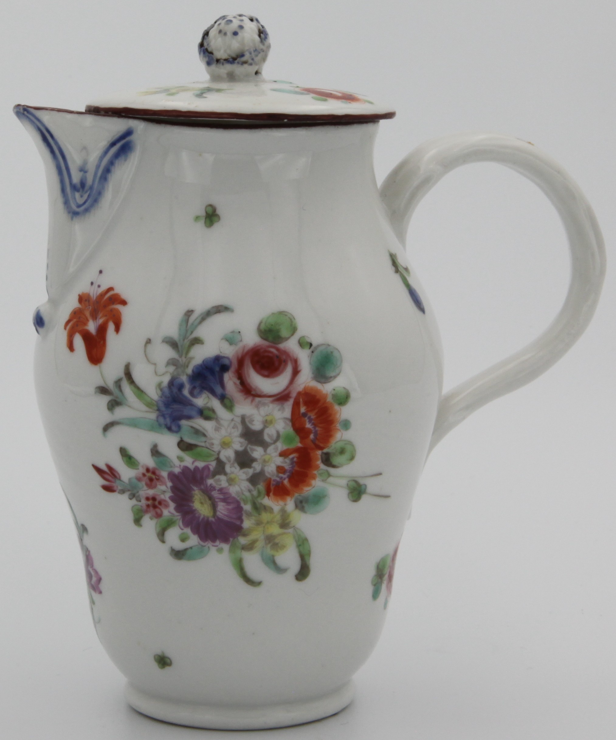A Bristol porcelain ovoid jug and flat cover, with a blue floral knop, twig shaped handle and moulded spout, decorated with sprays of garden flowers to front and back, and scattered leaves and flowers under and iron red rim, blue decoration under the spout, blue cross mark