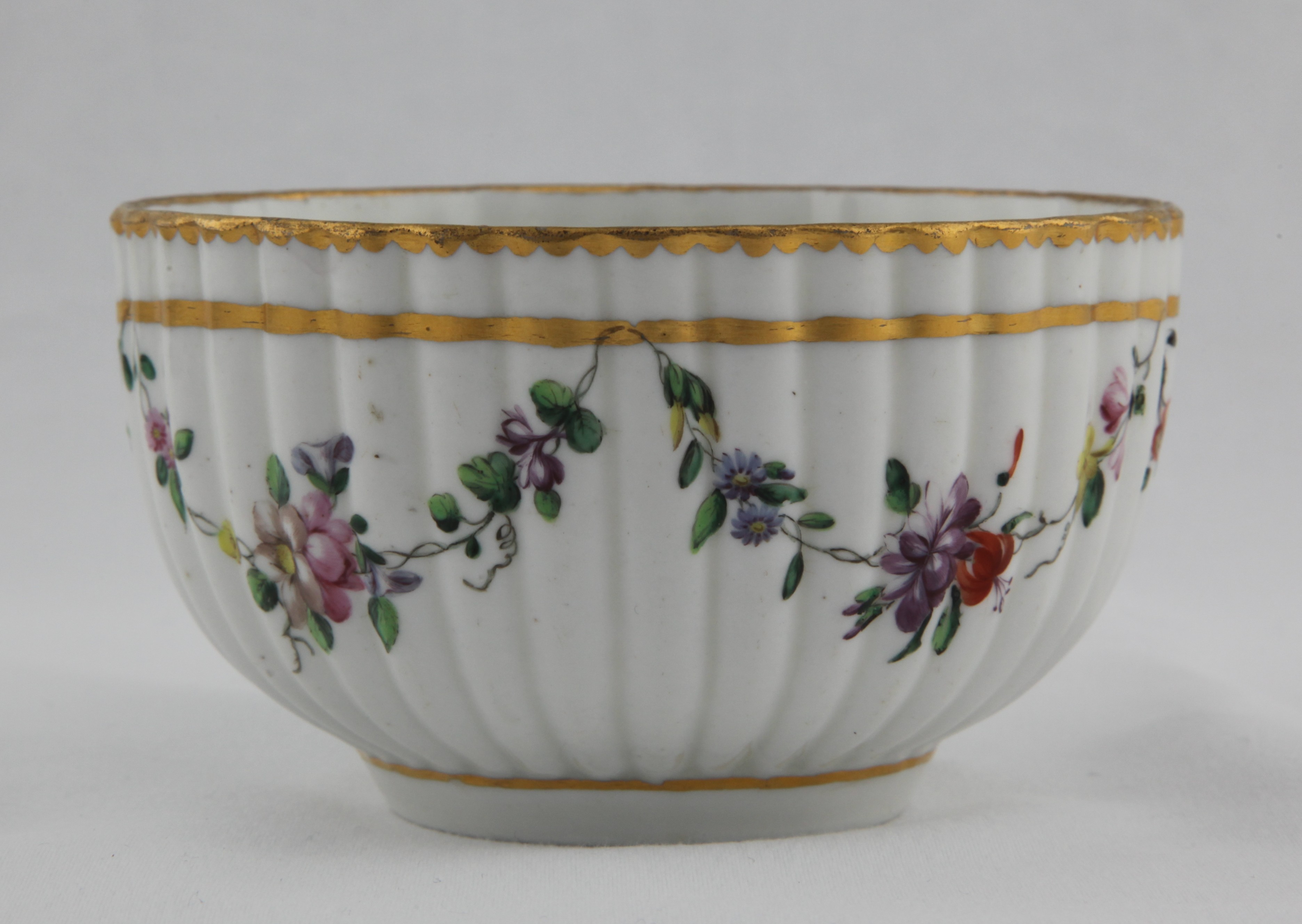 Bowl, from the Gold line garland service, decorated by 2, A fine Bristol fluted porcelain bowl finely painted with polychrome foliate swags suspended from a heavy gilt band, gilt dentil rim, floral spray to bottom of the bowl, the underside with underglaze blue cross mark and numeral 2. — Plymouth & Bristol porcelain piece 1239
