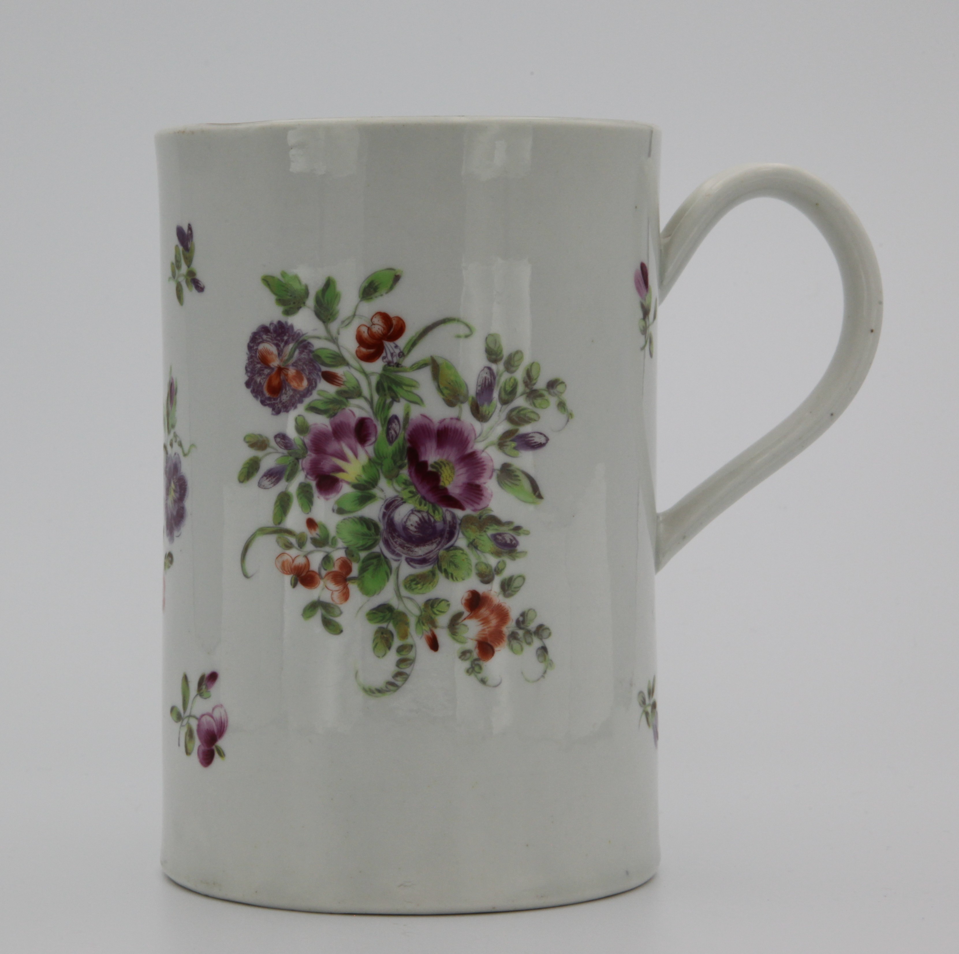 A large Bristol mug with convex plain handle decorated in gilt,  finely painted in enamels with sprays of flowers and leaves, gilt rim. 15.5 cm high. No mark but circle on base.