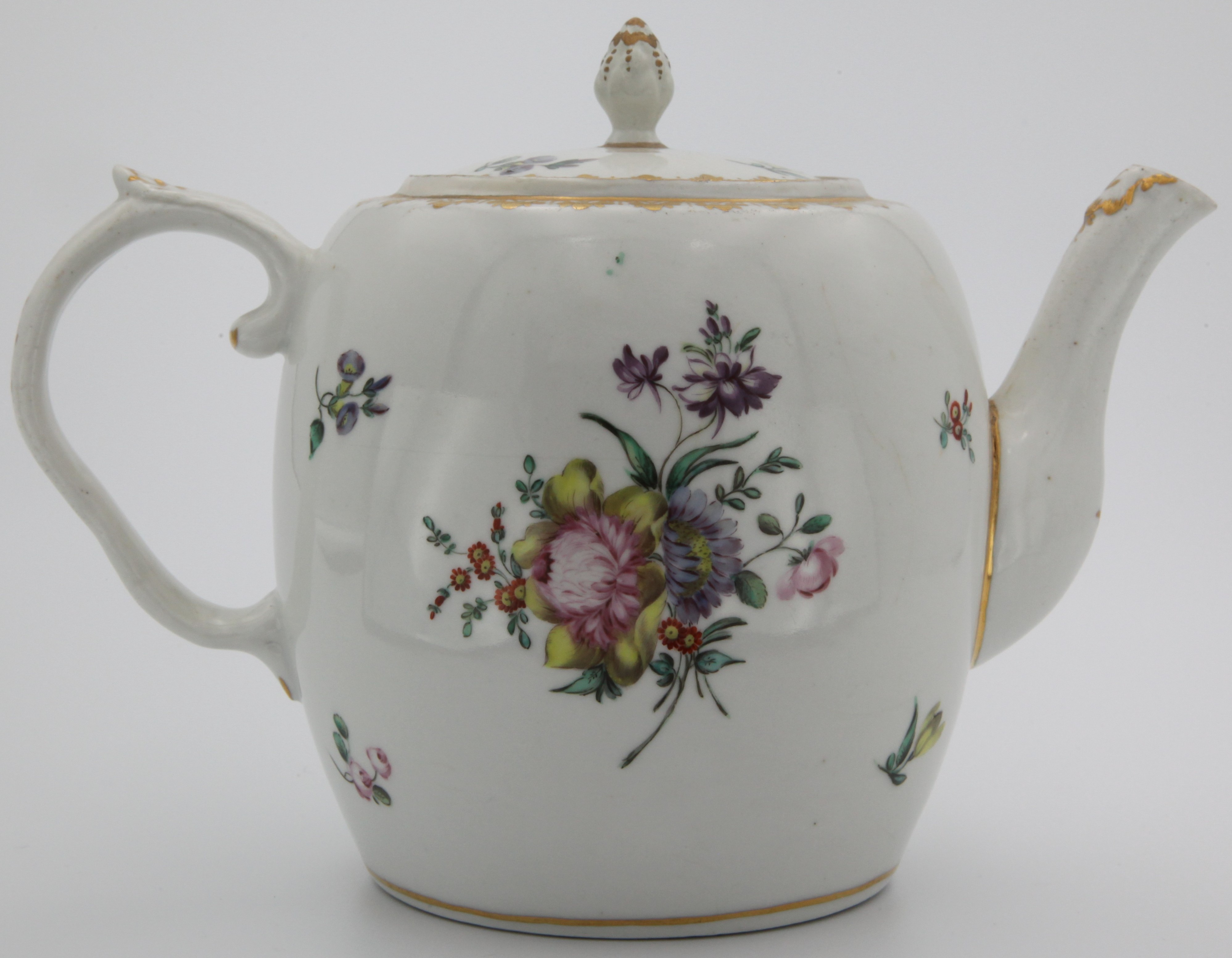 A Bristol porcelain teapot, of barrel form, with moulded ear-shaped handle, and cover with gilt-decorated bud finial, painted in enamels with floral sprays to front and back and with scattered leaves and flowers,elaborate gilt diaper border, painted X5. mark