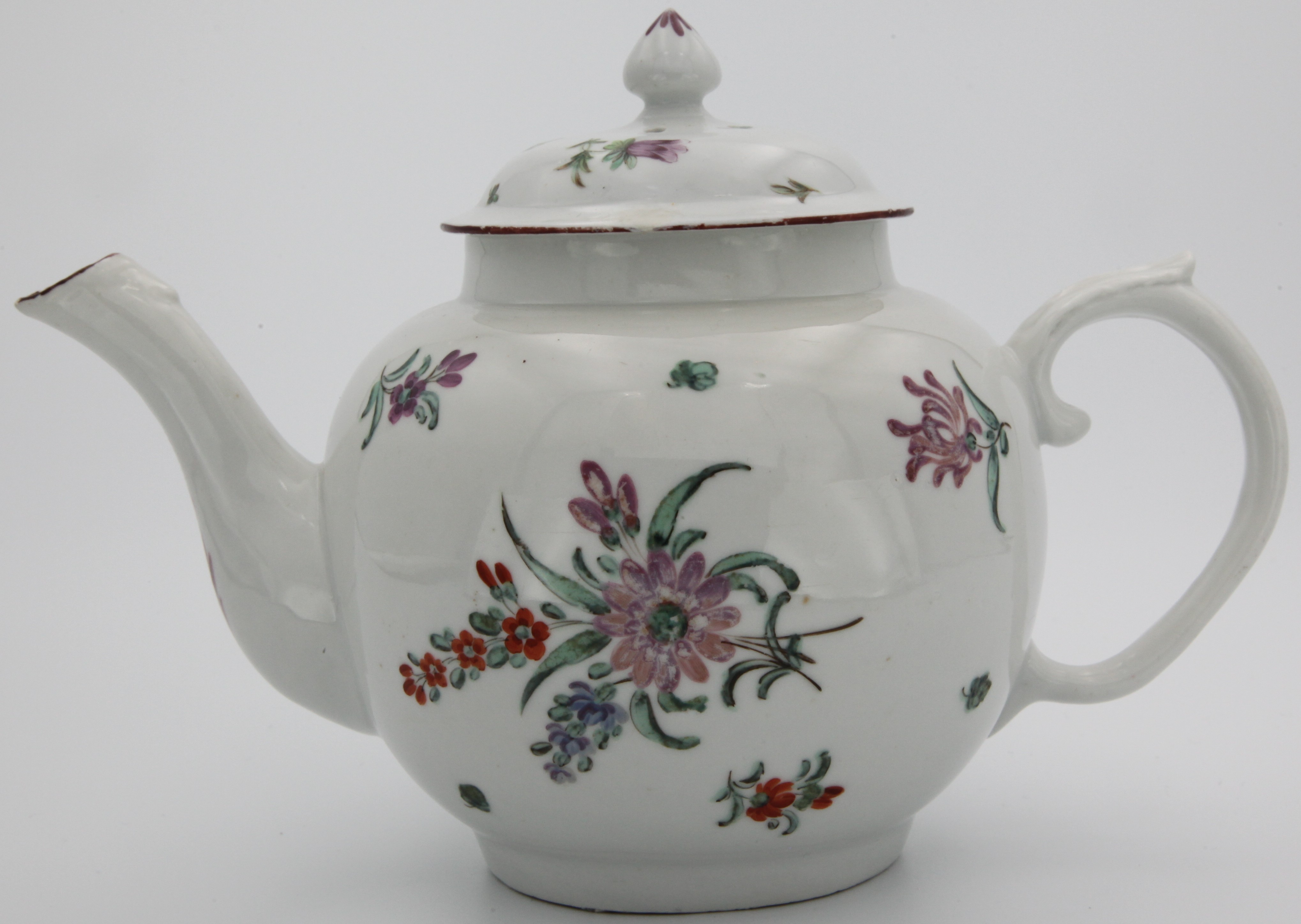 A  Bristol globular teapot and cover with bud finial painted purple and acanthus scroll ear-shaped handle, painted with scattered flower sprays and sprigs, purple rim line. blue X8 mark, circa 1770-75