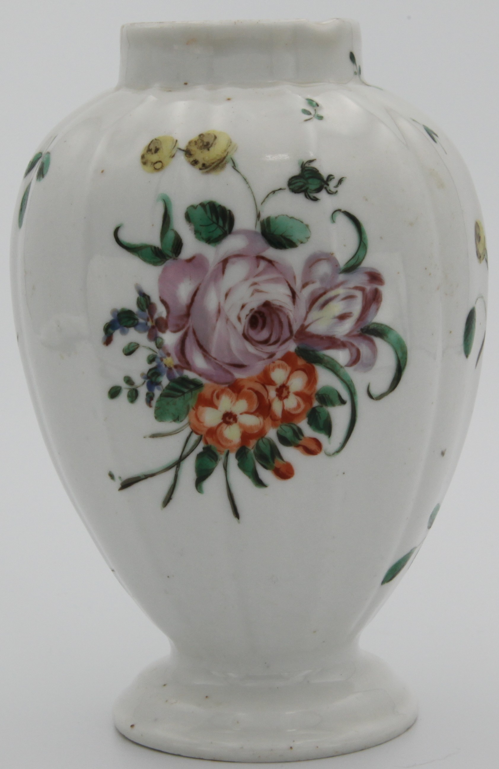 A Bristol tea canister of lobed baluster form with stepped base, painted in enamels with a loose bouquet and scattered sprays and leaves, circa 1775-80. No mark