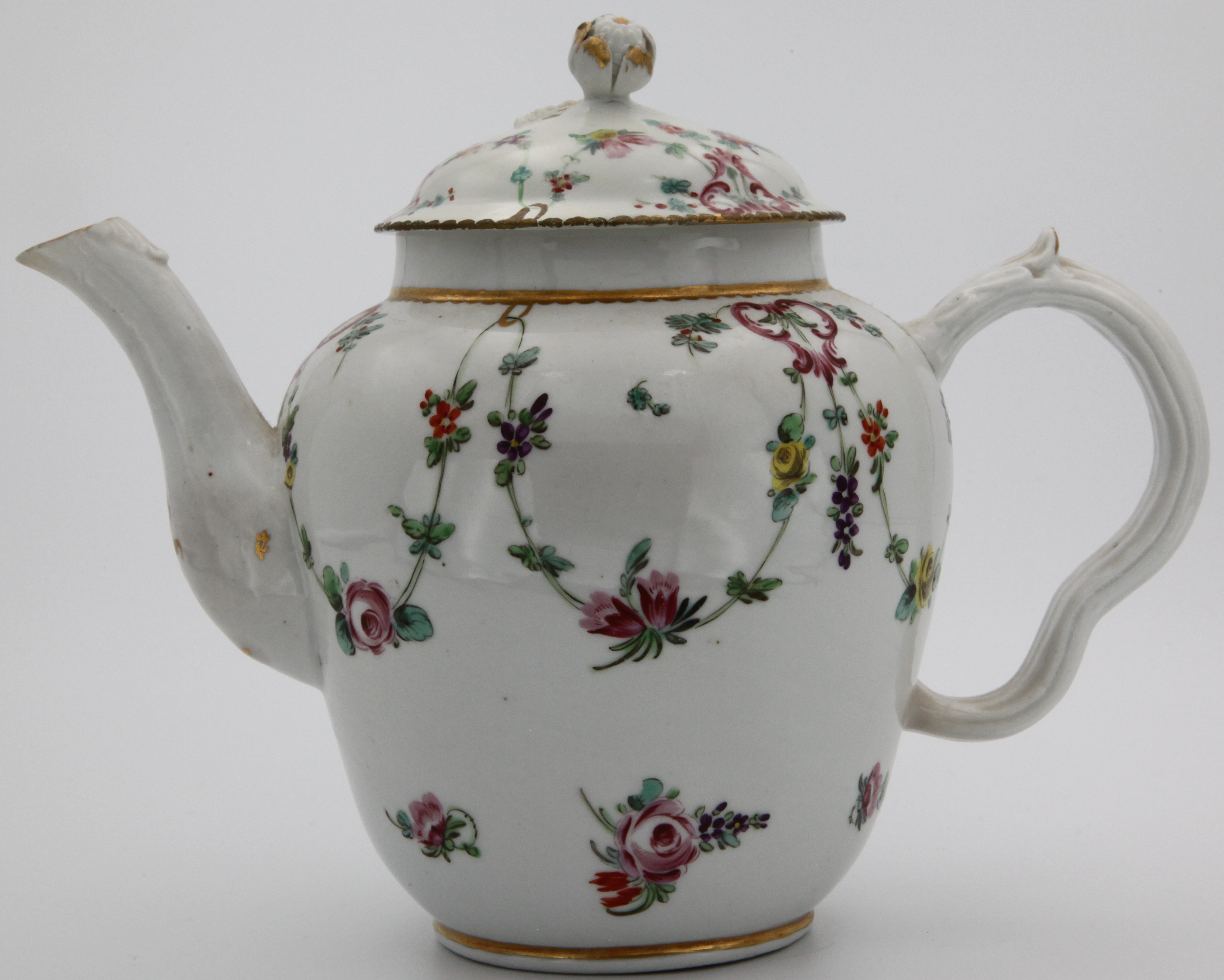 A Bristol teapot of ogee form, with ribbed ear-shaped handle, and cover  with gilt-decorated bud finial, painted with garlands of flowers suspended from puce cartouches and gilt loops hanging from a gilt dentil rim, crossed swords 1. mark, circa 1775-80