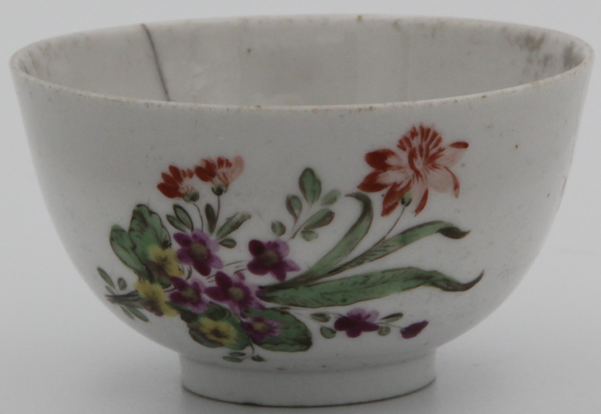 Bristol teabowl painted with floral spray,  scattered flowers and leaves to reverse and leaves at the bottom of the bowl. Circa 1775, no mark