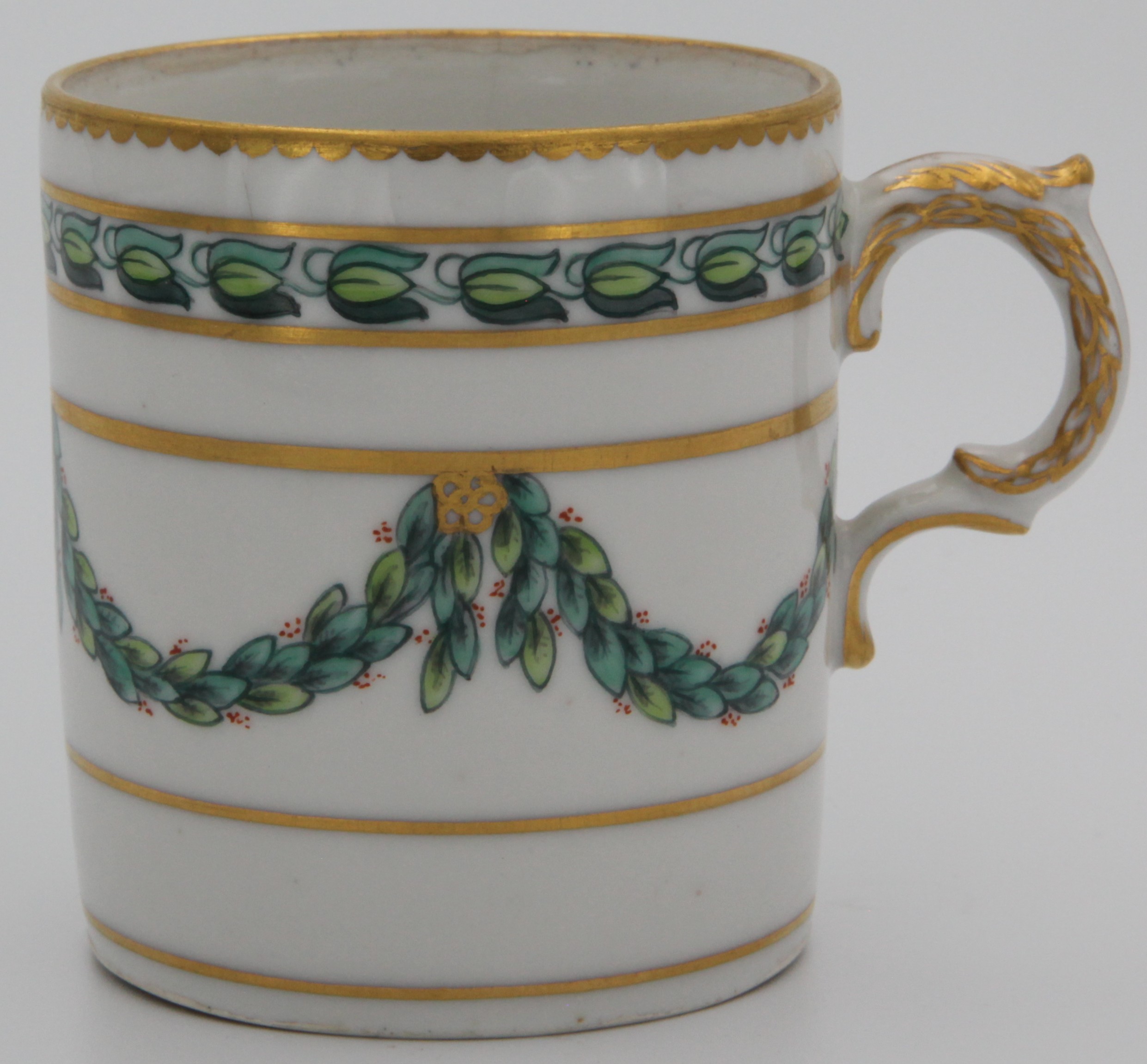 A Bristol ogee-shaped coffee cup, with harebell-moulded ear-shaped handle, painted in green and iron red with laurel swags, suspended from gilt bands within green leaf scroll bands and gilt dentil rims, circa 1775. Blue X3 mark