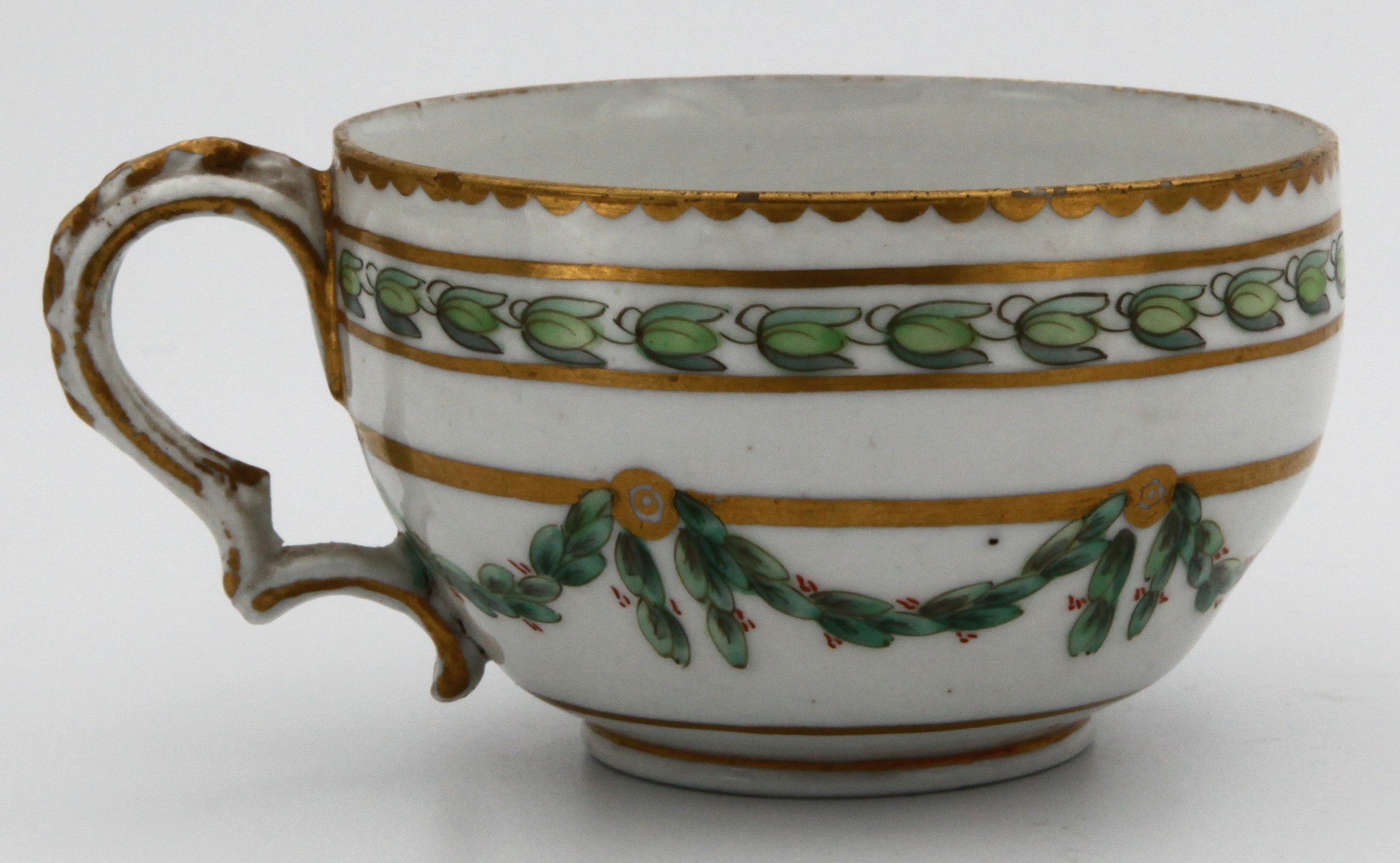 A Bristol round-shaped teacup with harebell-moulded ear-shaped handle, painted in green and iron red with laurel swags, suspended from gilt bands within green leaf scroll bands and gilt dentil rims, circa 1775, blue painted X1. mark.