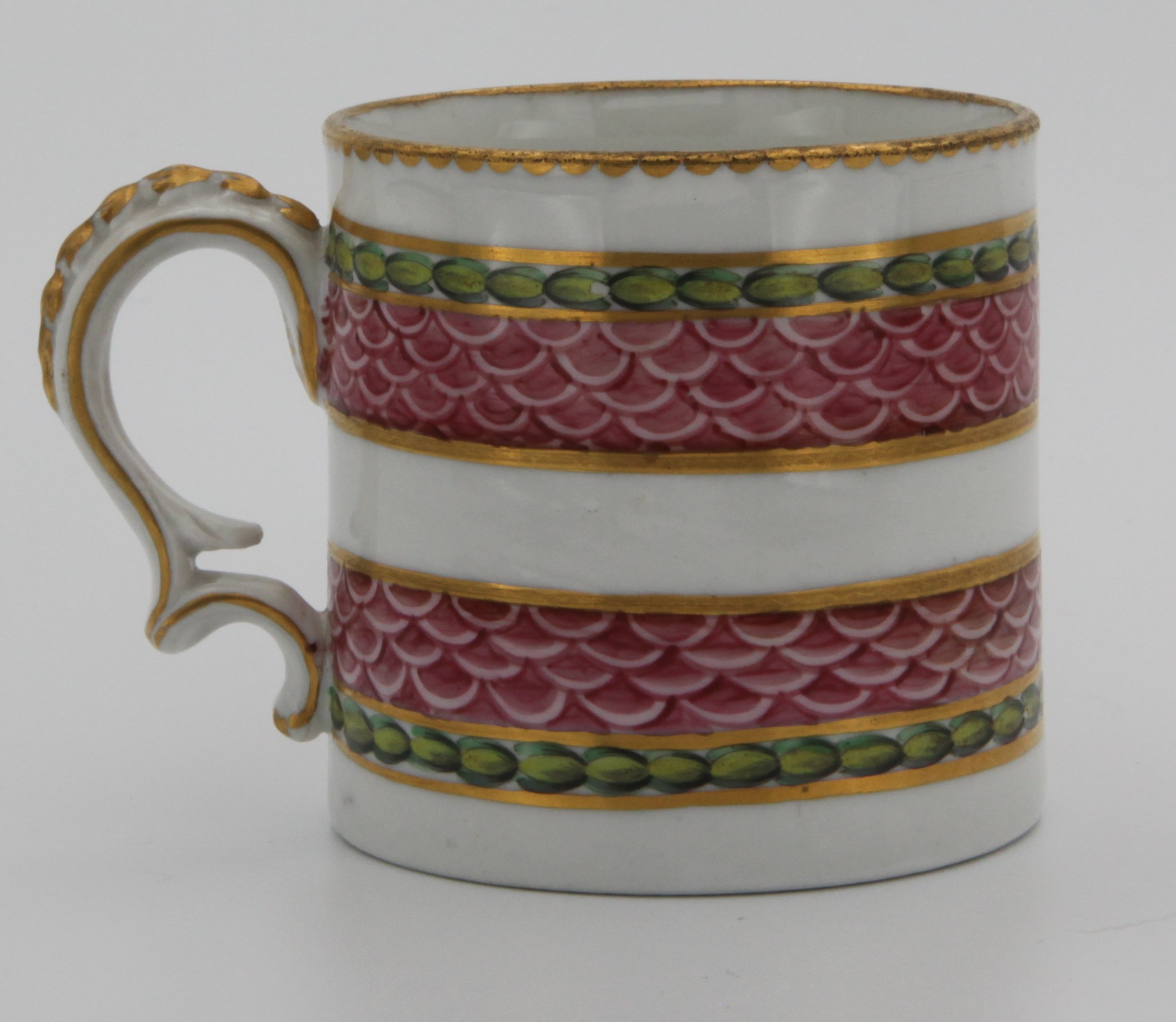 A fine Bristol coffee can with harebell moulded scroll handle, painted in pink with scale bands, within green laurel borders, gilt dentil rims, circa 1775, blue painted X.  See Albert Amor Limited, The Alfred Trapnell Collection, 1912, numbers 27 and 28 for similar examples