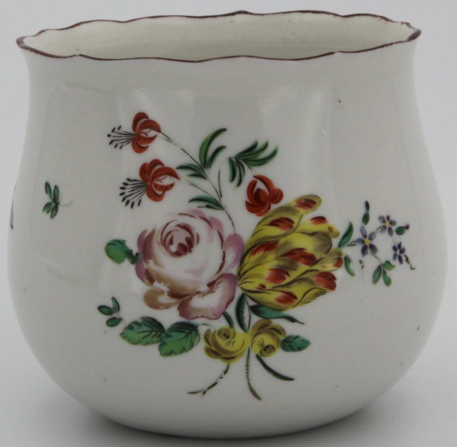 A rare Bristol baluster shaped finger bowl, painted in coloured enamels with a spray of flowers and leaves, and scattered flowers, the barbed rim with a brown band, circa 1772, no mark. Unfinished base.