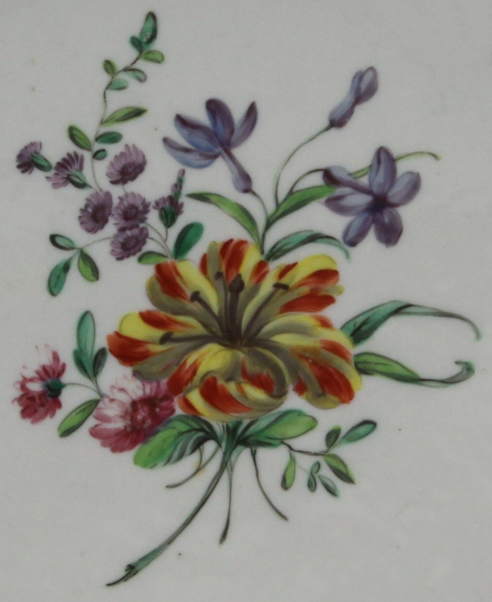 A lobed Bristol plate painted in coloured enamels with a spray of flowers and leaves,  the border with gilt dentil rim, circa 1775, blue painted Xb mark.