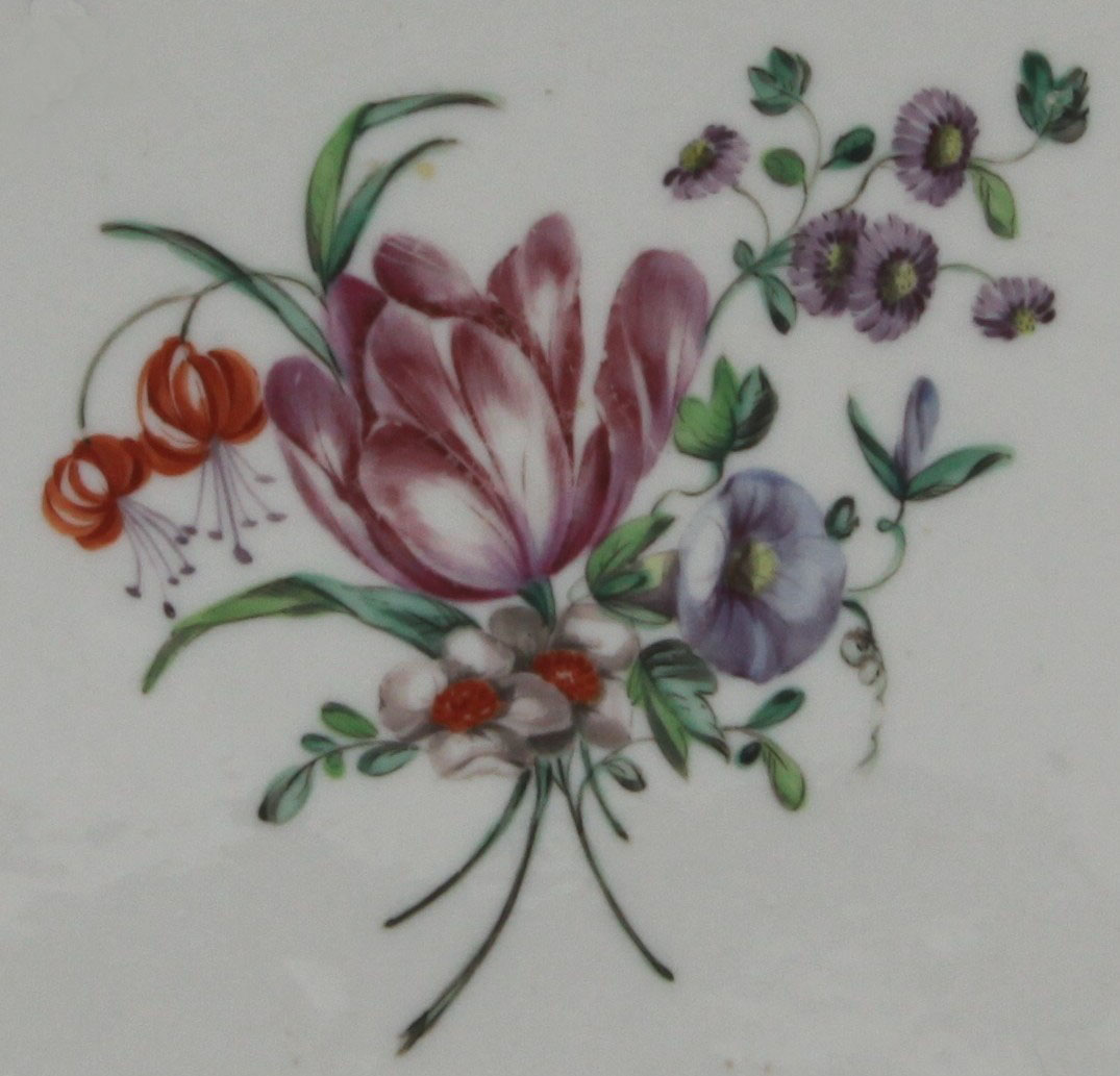 A lobed Bristol plate painted in coloured enamels with a spray of flowers and leaves,  the border with gilt dentil rim, circa 1775, blue painted Xb mark.