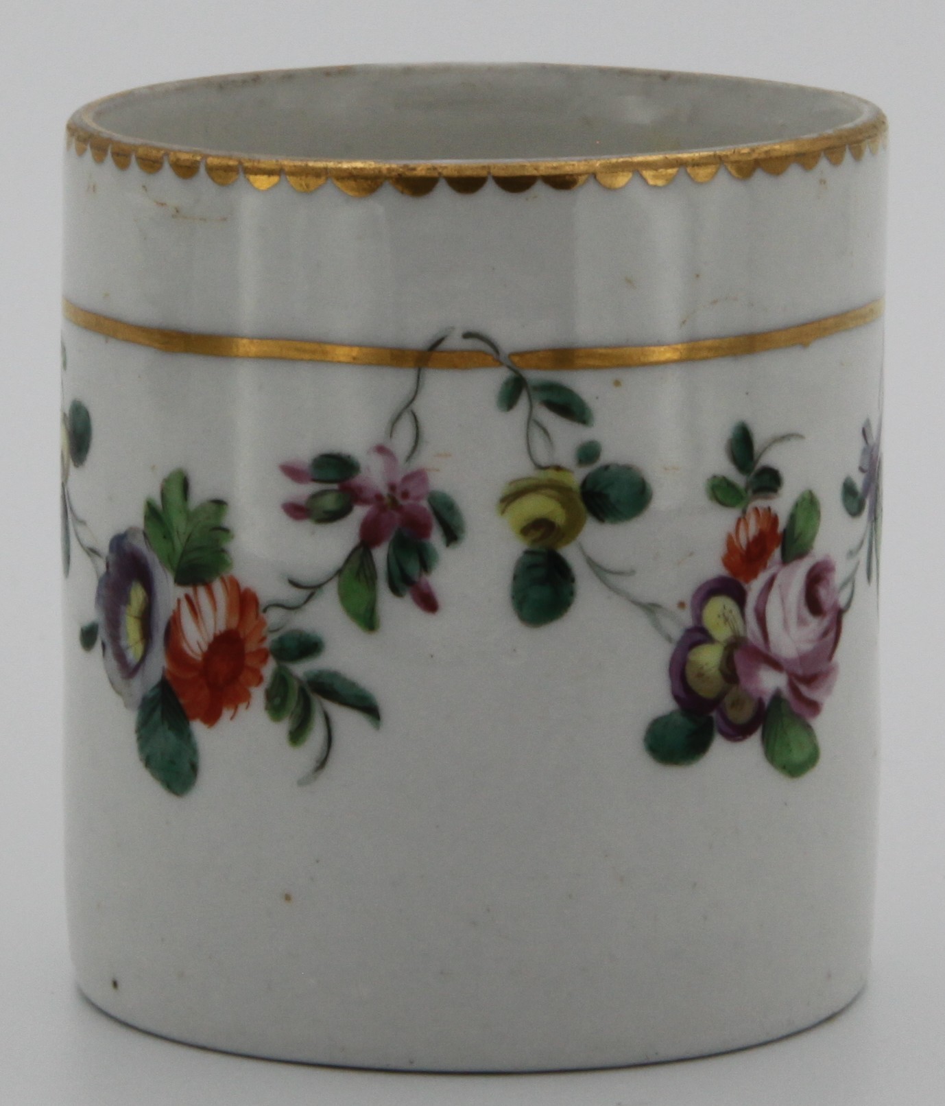 A Bristol cylindrical toilet pot, painted in coloured enamels with swags of flowers and leaves, suspended from gilt bands, within gilt dentil borders, circa 1772-75, blue B3 mark.
