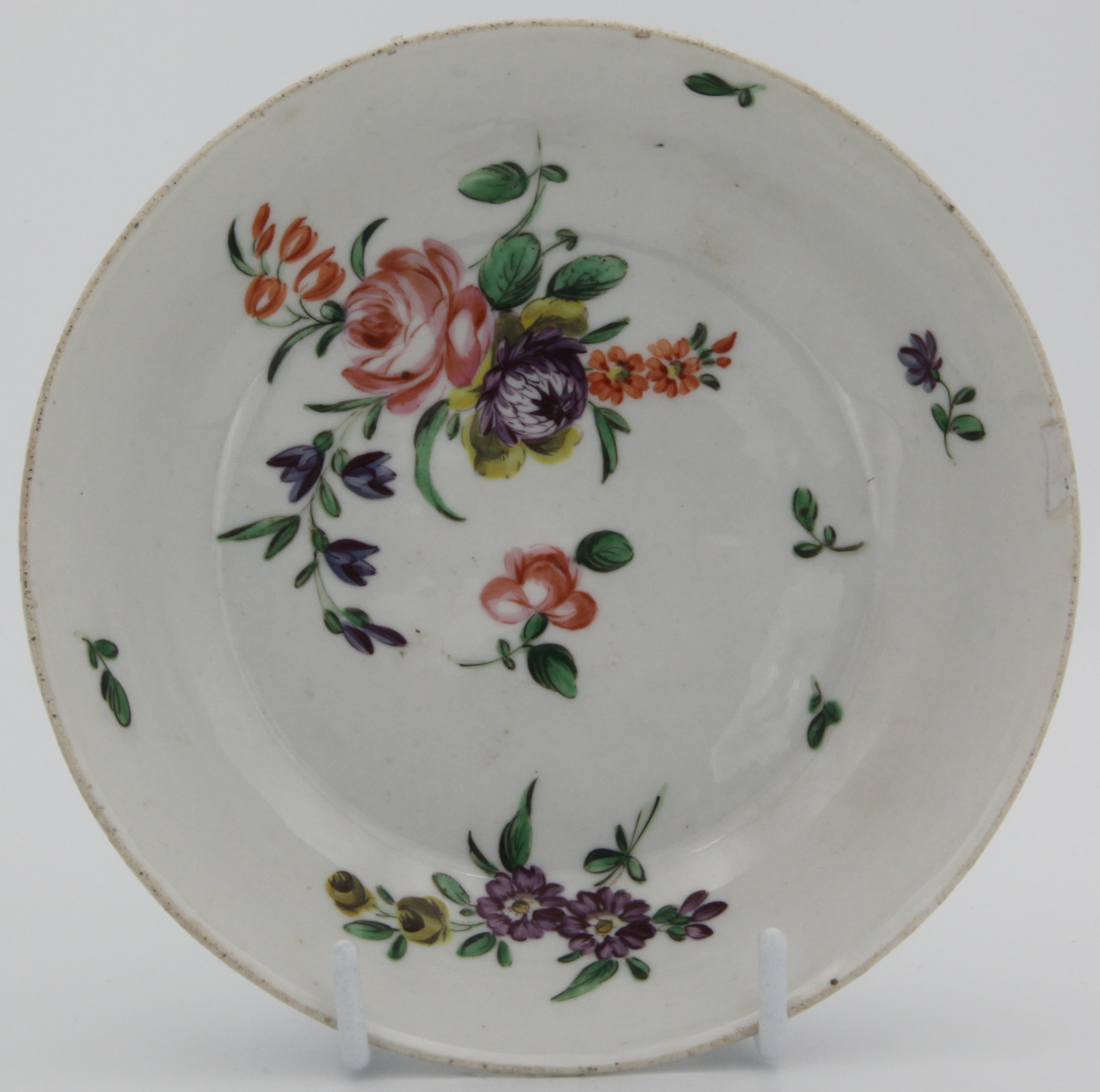 A deep Bristol saucer painted with colourful enamel sprays, blue B7 mark.