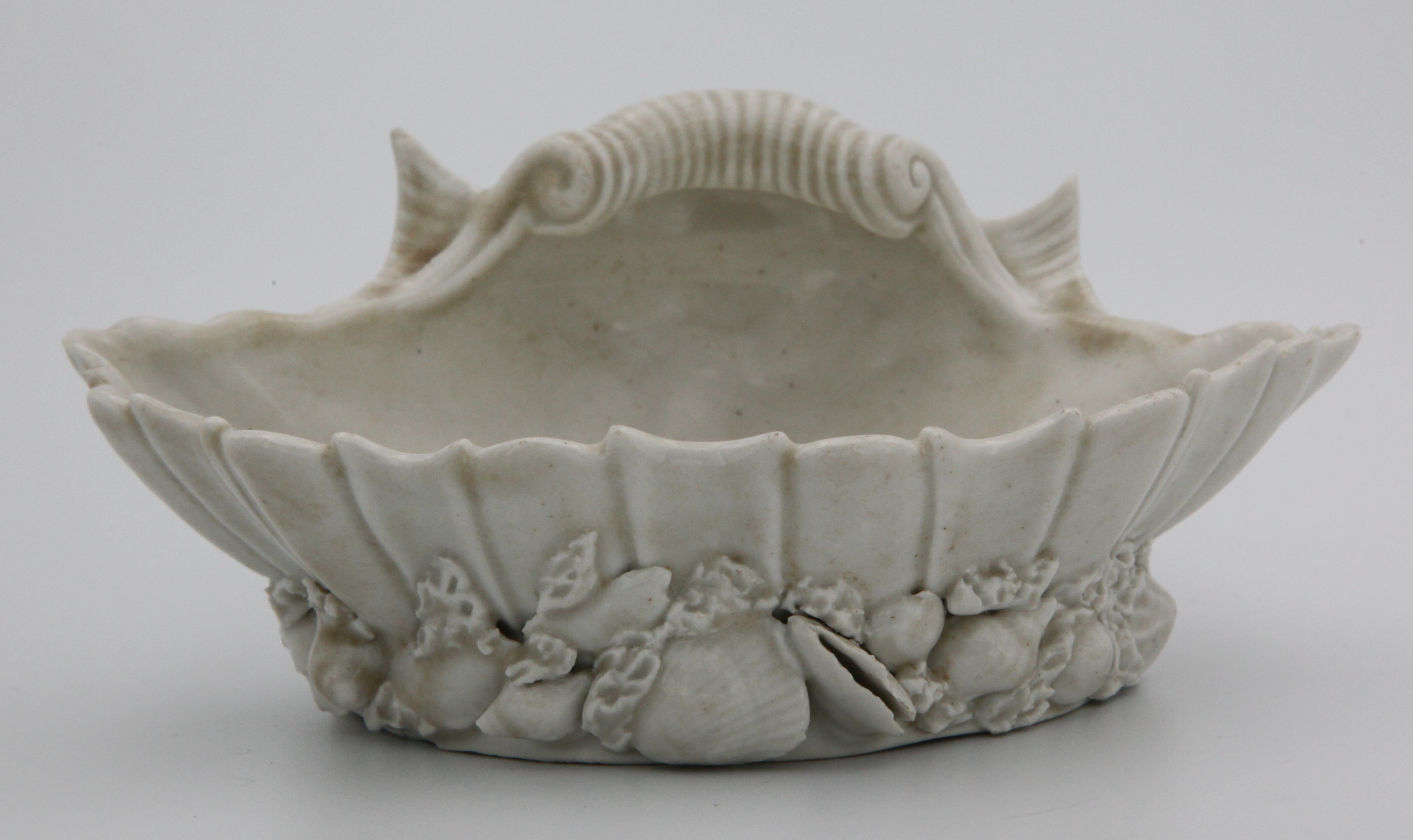 A Plymouth fine rare salt modeled as a shell upturned on smaller shells and seaweed having an all-over smokey glaze. c. 1768-70  Mark: None.