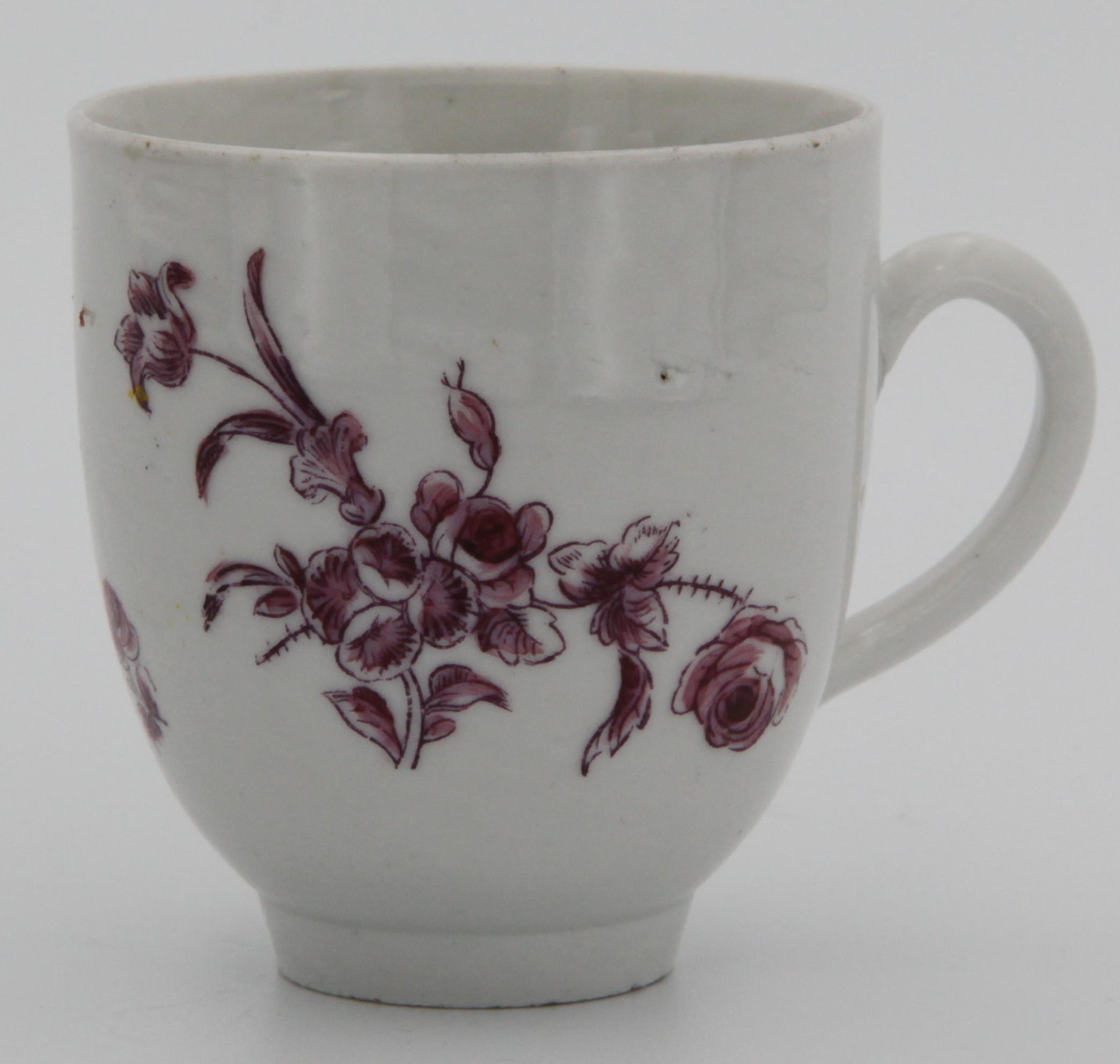 A Bristol coffee cup painted in purple with  sprays of flowers to front and reverse c. 1772-75. Mark: none.