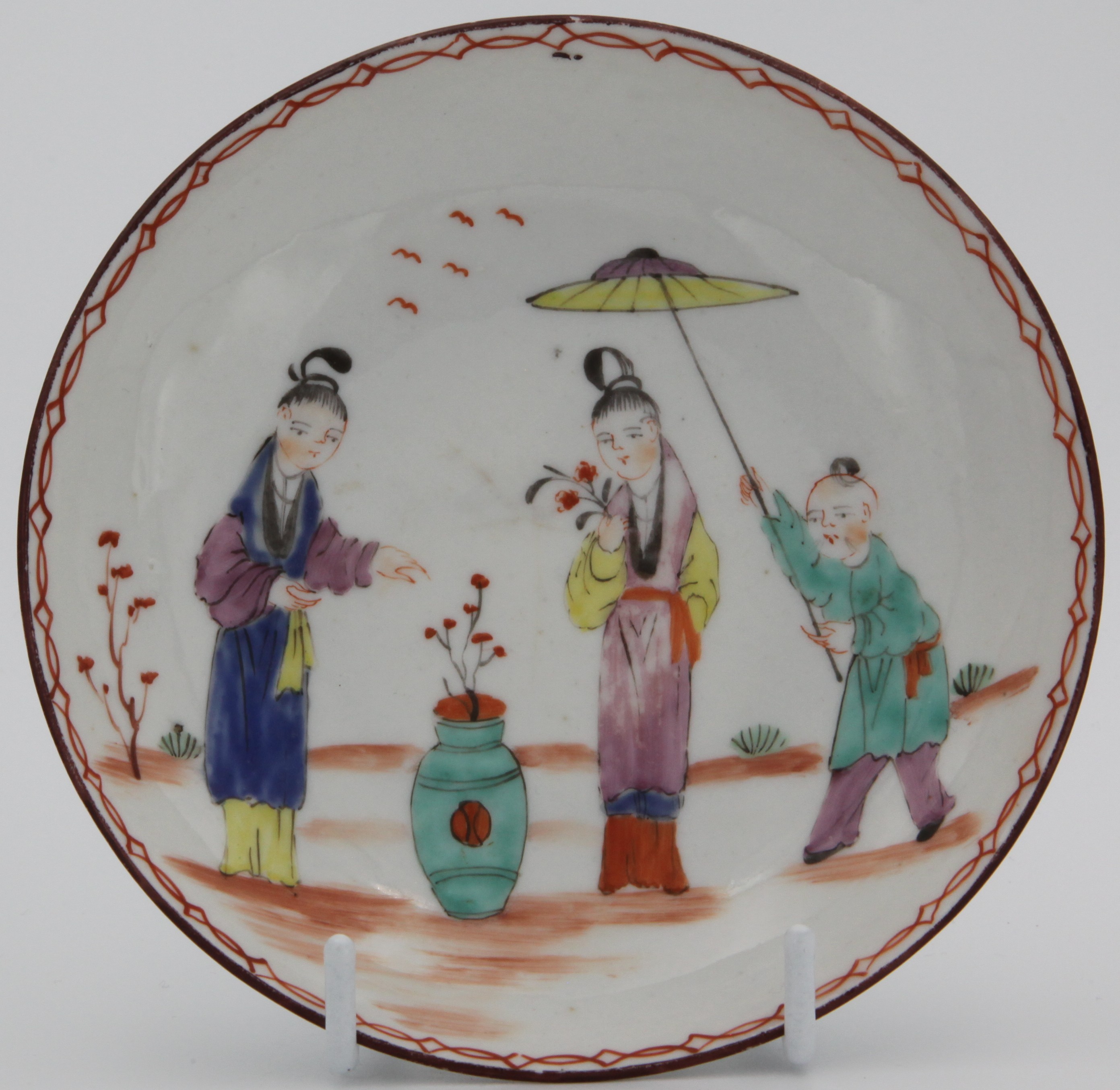 A Bristol saucer painted with oriental figures under a chain link border c. 1775. Mark: none.