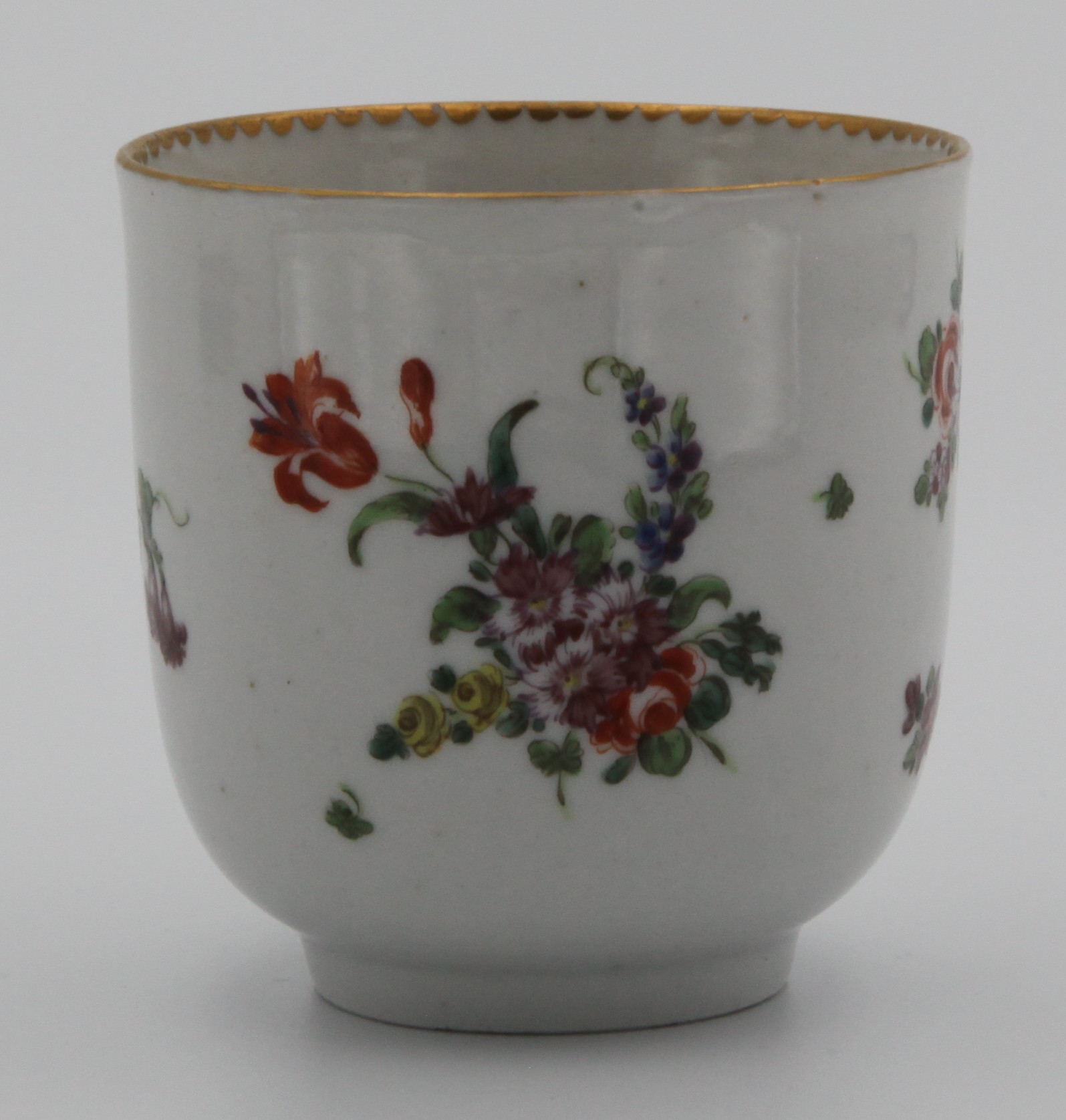 A Bristol coffee cup with rounded twig handle, painted with scattered flower sprays and sprigs with solid and dentil gilt borders, circa 1775-80. No mark.