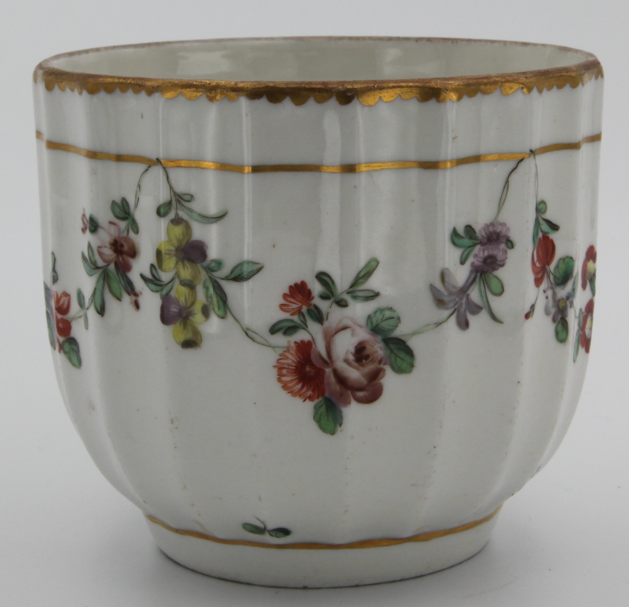 A Bristol fluted sucrier, painted in enamels with garlands of colourful flowers and leaves suspended from a gilt line, heavy gilt dentil border, grey Xb mark, c.1770