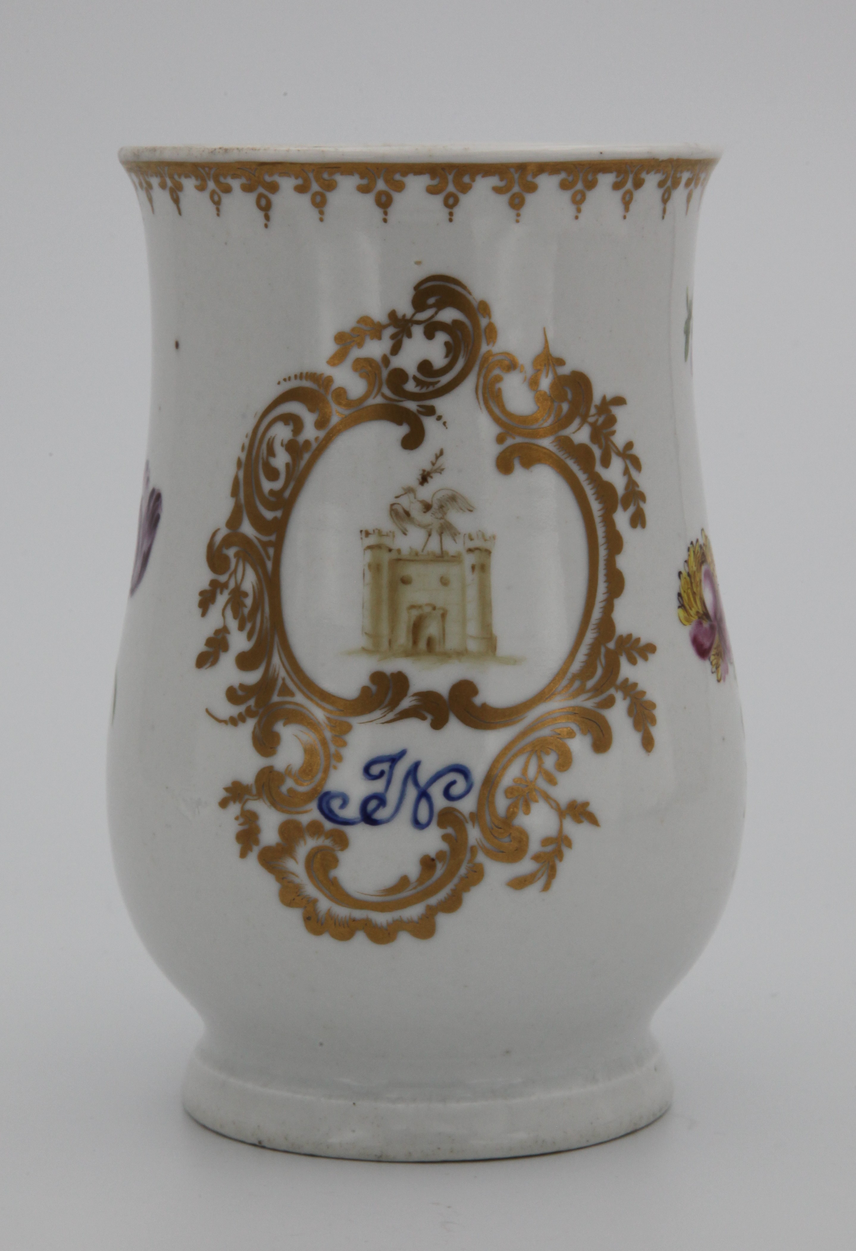 Mug, from the Armorial and initials service, decorated by No mark, A Plymouth baluster shaped mug, with notched loop handle, painted in sepia with the crest of Sir John Nicholls, and monogram 'JN' in dry blue enamel, within an elaborate 'C' scroll and leaf cartouche, flanked by coloured sprays of flowers and leaves, beneath a gilt pendant flower head and scroll band, circa 1770, painted tin mark in puce — Plymouth & Bristol porcelain piece 1467