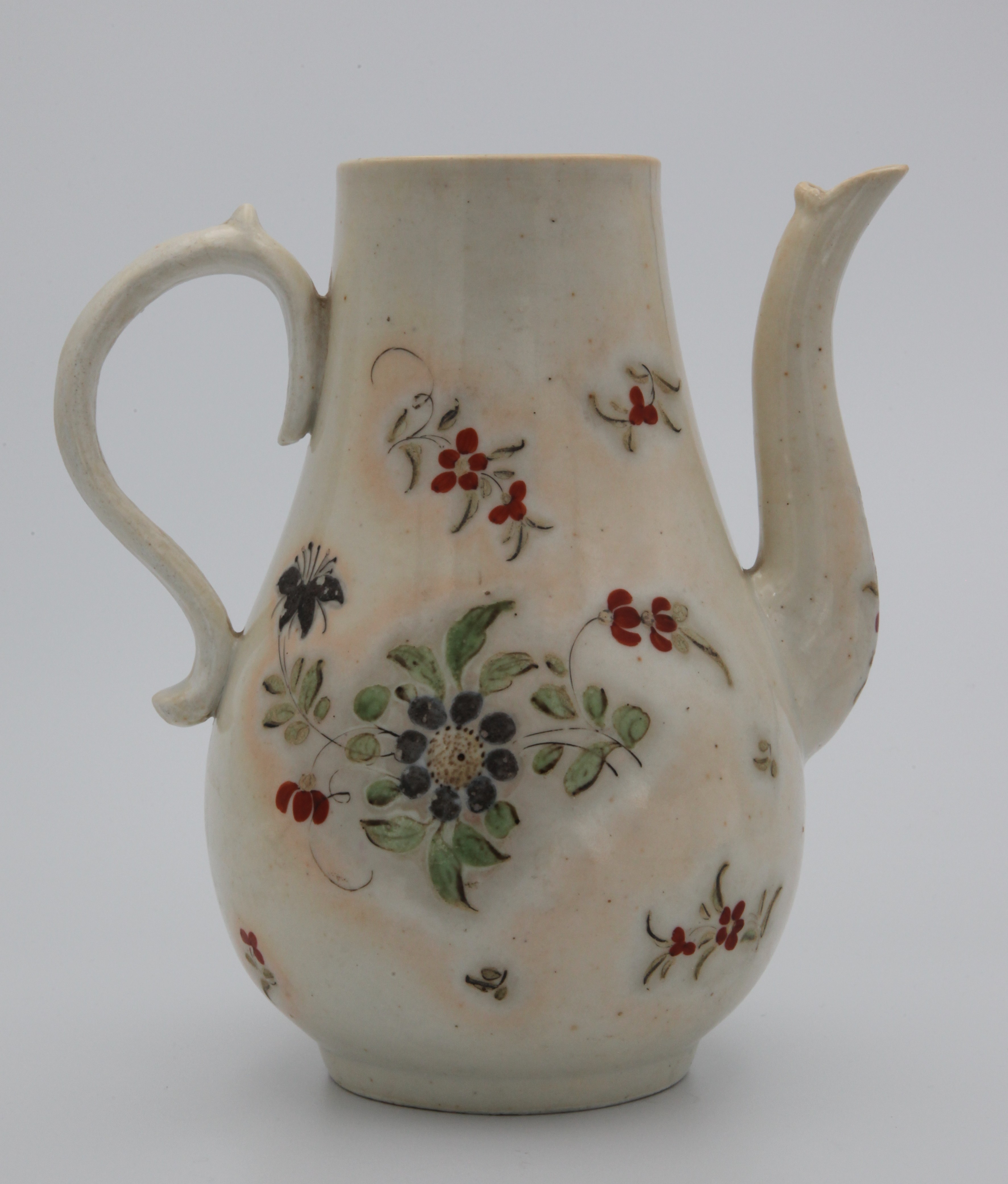 A Bristol coffee pot, c1770, of baluster form, with S-shaped handle, with dark smoky glaze, painted with flowers and scattered sprigs, 20cm h, overglaze blue X