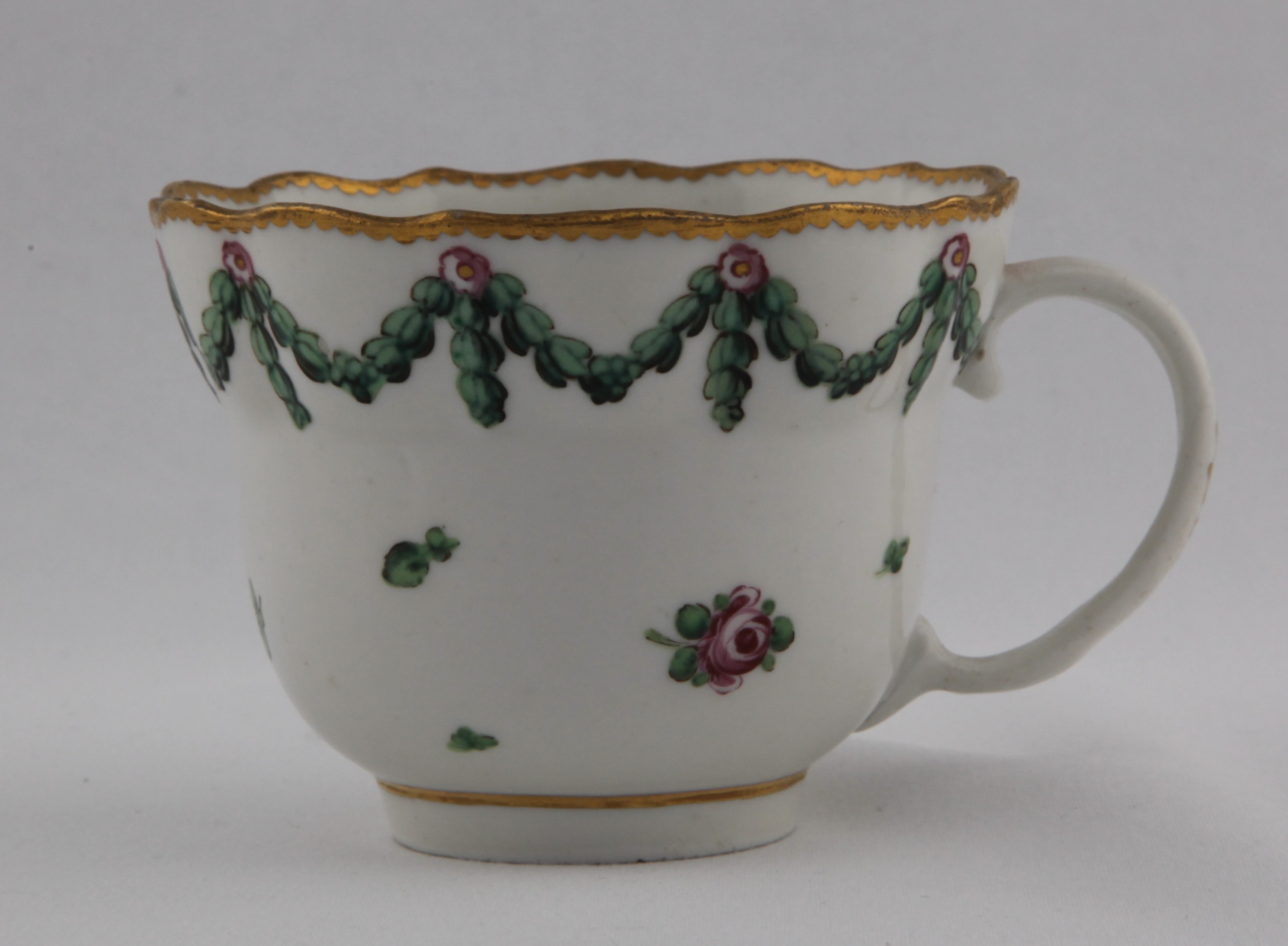 Cup, decorated by 4, A Bristol ogee-shaped chocolate cup with plain loop and gilt decorated handle, painted with scattered sprigs under green acanthus garlands hanging from rose roundels under a gilt dentil rim. Mark: 4. in gold — Plymouth & Bristol porcelain piece 1483