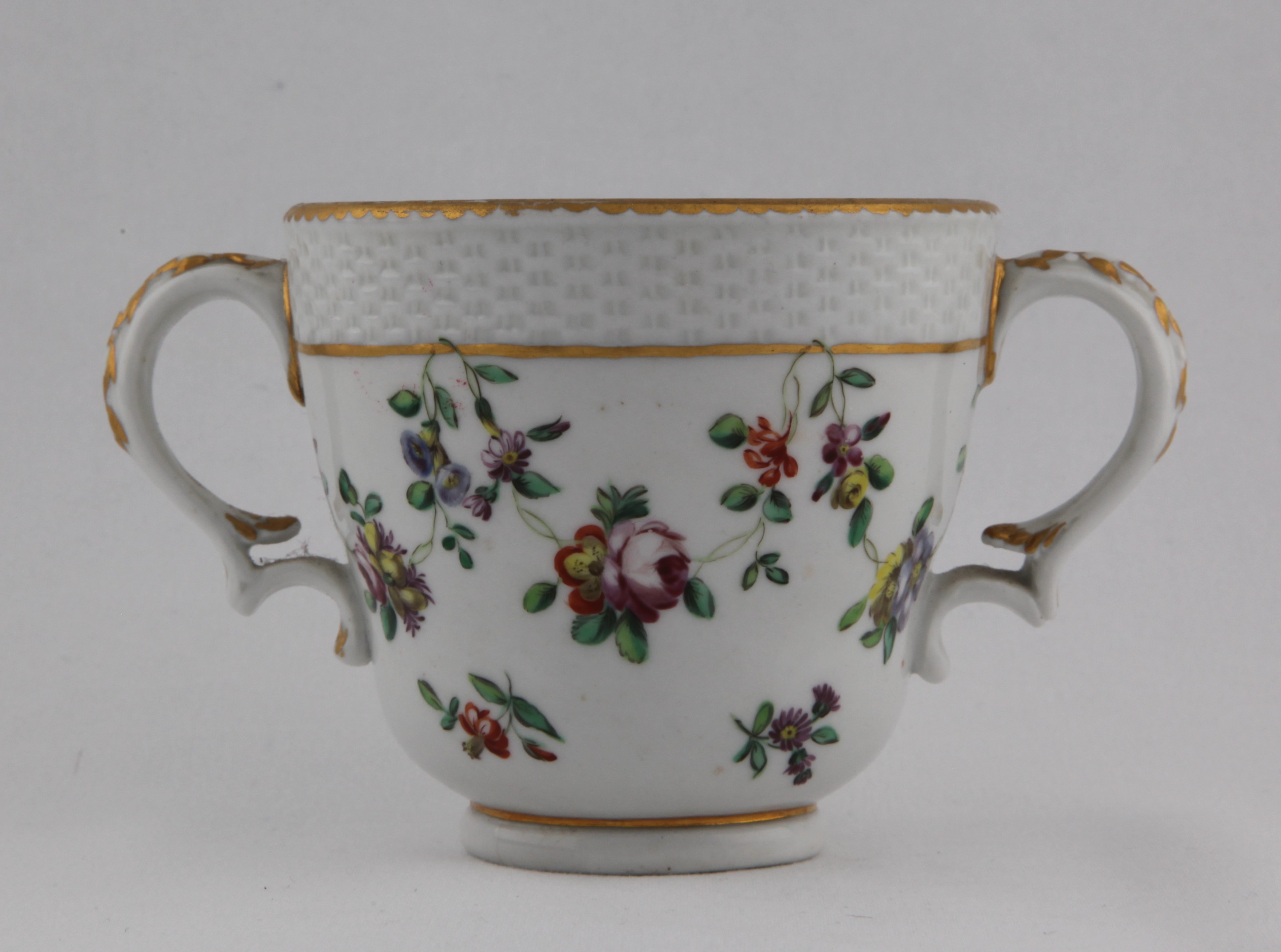 Covered cup, from the Gold line garland service, decorated by 5, A Bristol double handed cup, the handles harebell moulded scrolls, basket moulding to the top quarter of the cup and painted in enamels with a garland of colourful flowers and leaves looping over a gilt line, all under a gilt dentil rim — Plymouth & Bristol porcelain piece 1501