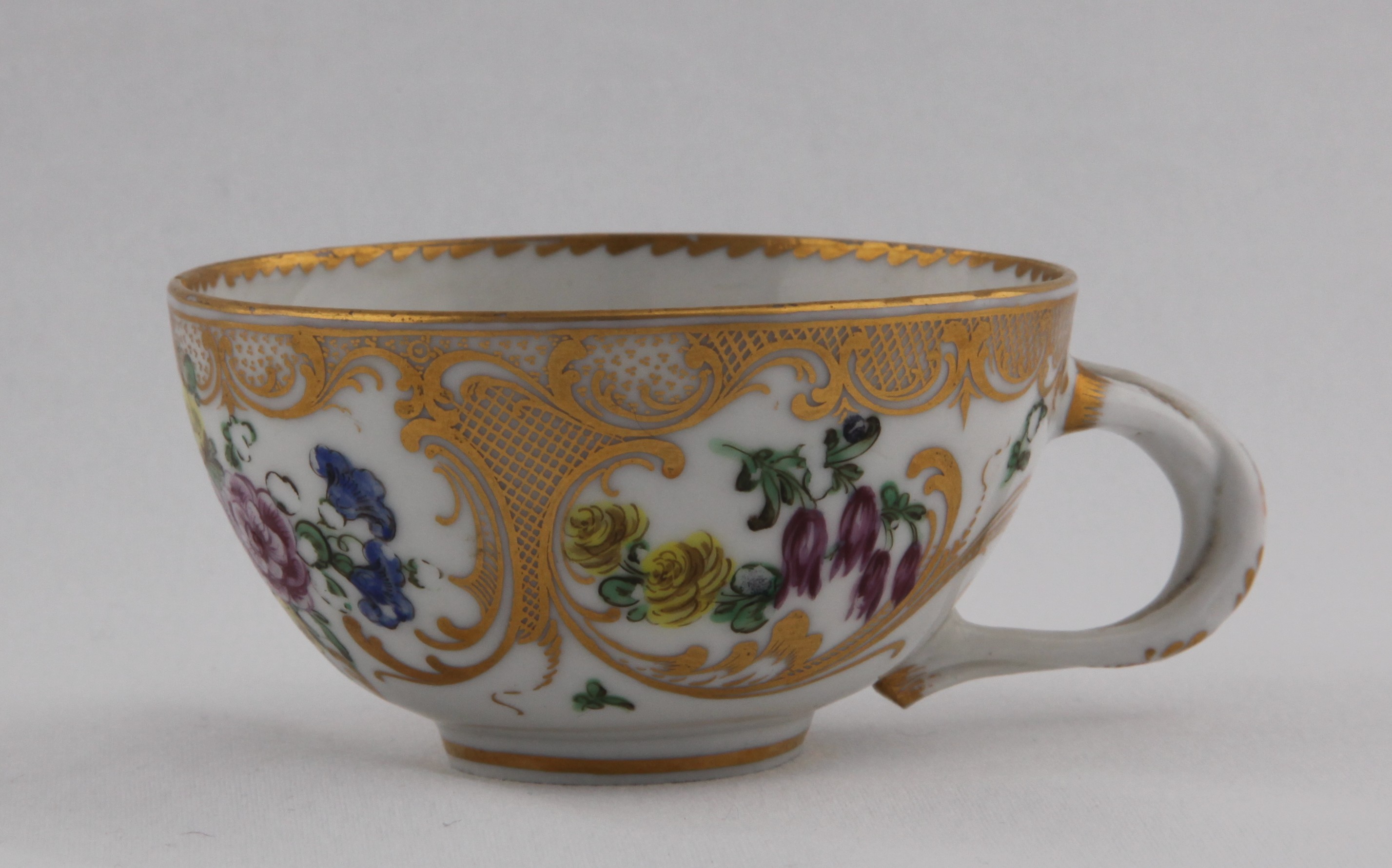 Cup, decorated by No mark, A very fine, heavily gilded Bristol tea cup, with entwined double loop handle, painted in enamels with colourful flowers surrounded by extensive cross-hatched gilding and scrolls all under an angular gilt dentil rim line — Plymouth & Bristol porcelain piece 1502