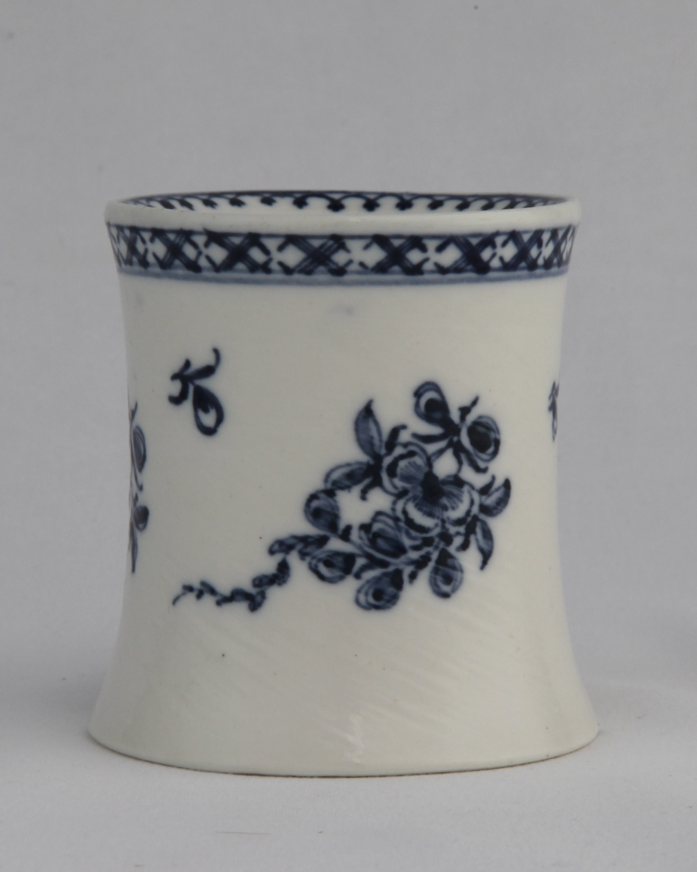 Sander, from the Bouquet with trailing strand service, decorated by No mark, An exceptionally rare Bristol (William Cookworthy) pounce pot or sander, circa 1772. Of elongated capstan form, the upper surface pierced with a formal design below a crowsfoot border painted in blue, the sides with neat trailing flowers and smaller sprigs, a diaper border above, 7.7cm high, cross in underglaze blue — Plymouth & Bristol porcelain piece 1506