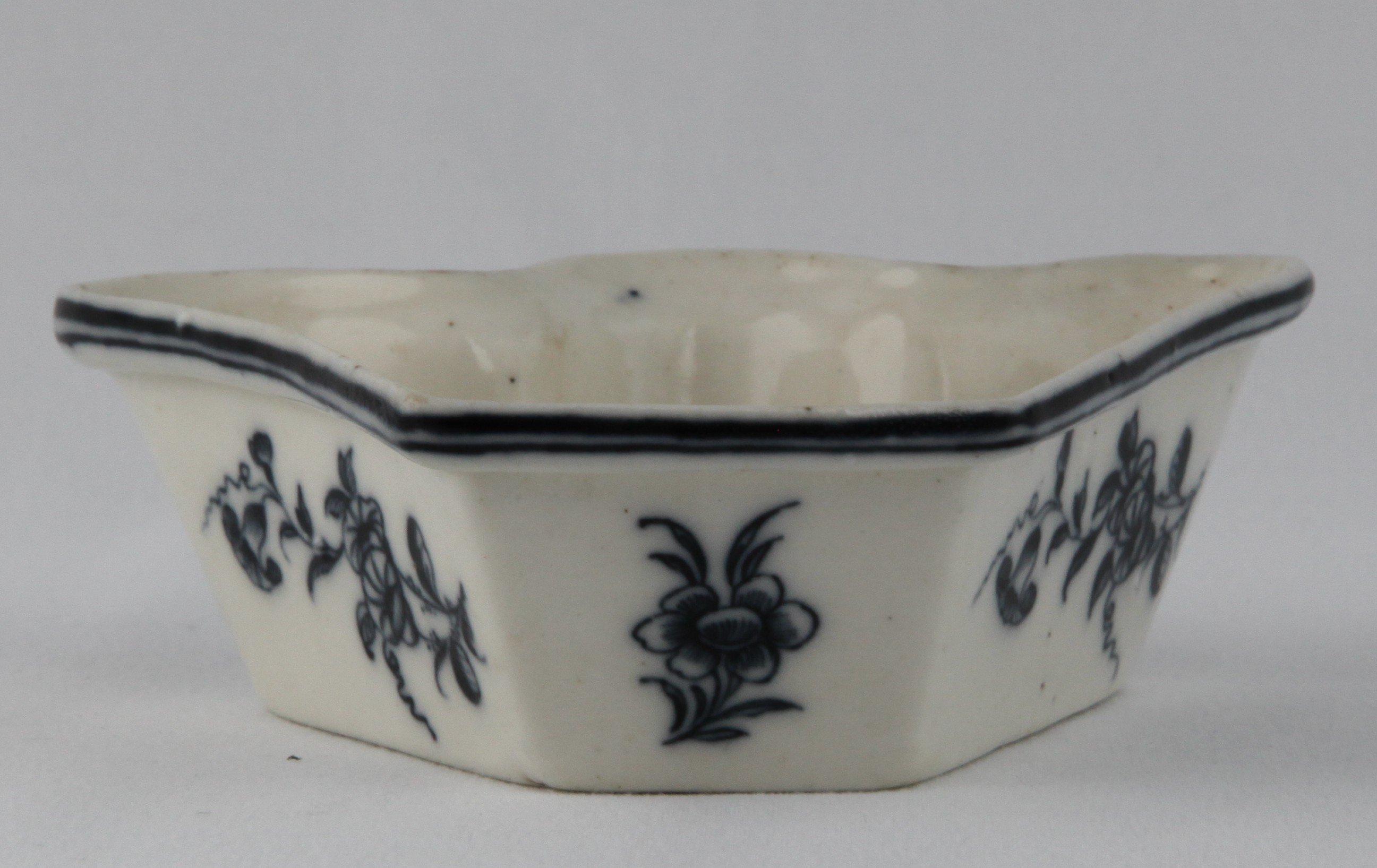 A Plymouth fan shaped dish, from an hors d'oeuvre set, the exterior painted in underglaze blue with simple flower sprays, beneath a narrow diaper band, 4 3/4" wide, circa 1770, no mark