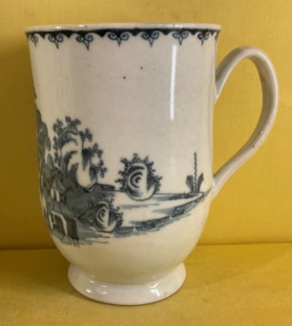 A Plymouth slender baluster shaped mug, with notched loop handle, painted in underglaze blue in Chinese style with a central pavilion, in an extensive river landscape with a fence, bamboo and rockwork, beneath a stylised ruyi head band, 5" high, circa 1770, blue painted tin mark