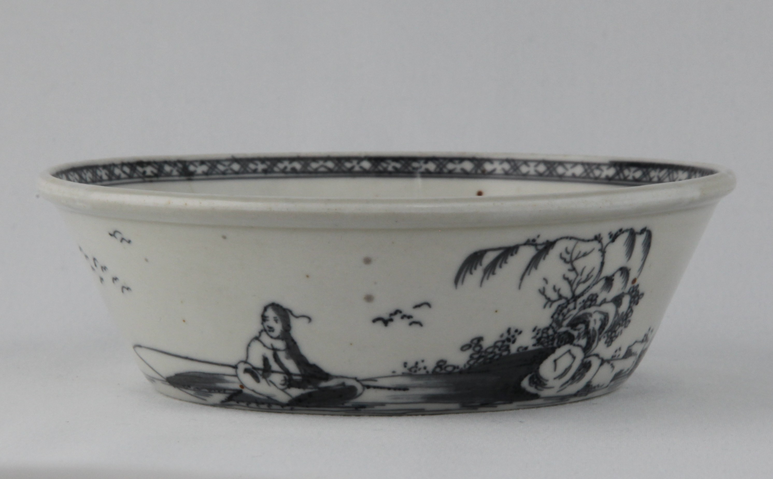 A Plymouth flared round tart pan, the exterior painted in underglaze blue in Chinese style with a seated fisherman in a continuous river landscape, the interior with a narrow diaper band, 5 1/2" diameter, circa 1770