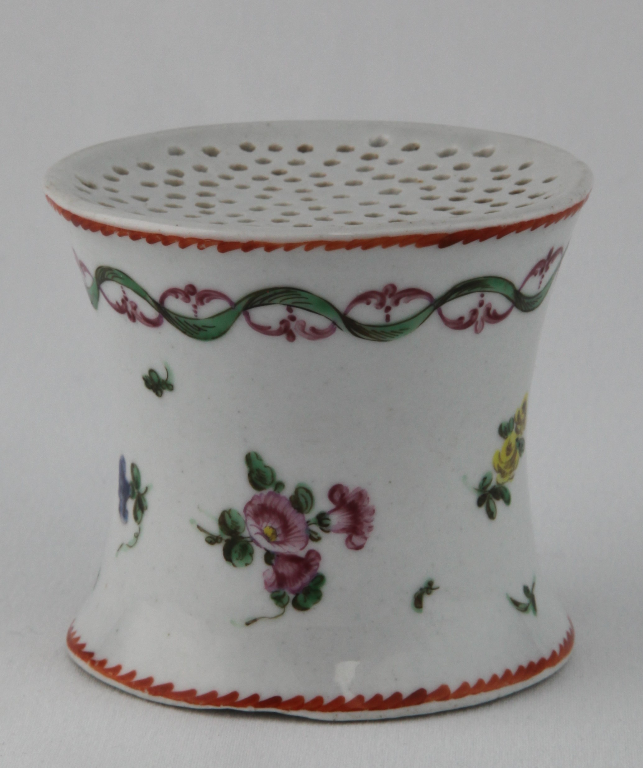 An extremely rare Bristol sander, of waisted form, painted in coloured enamels with flower sprigs, beneath a puce and green entwined scroll and ribbon band, within angular orange dentil borders, 2 3/4" high, circa 1772, no mark