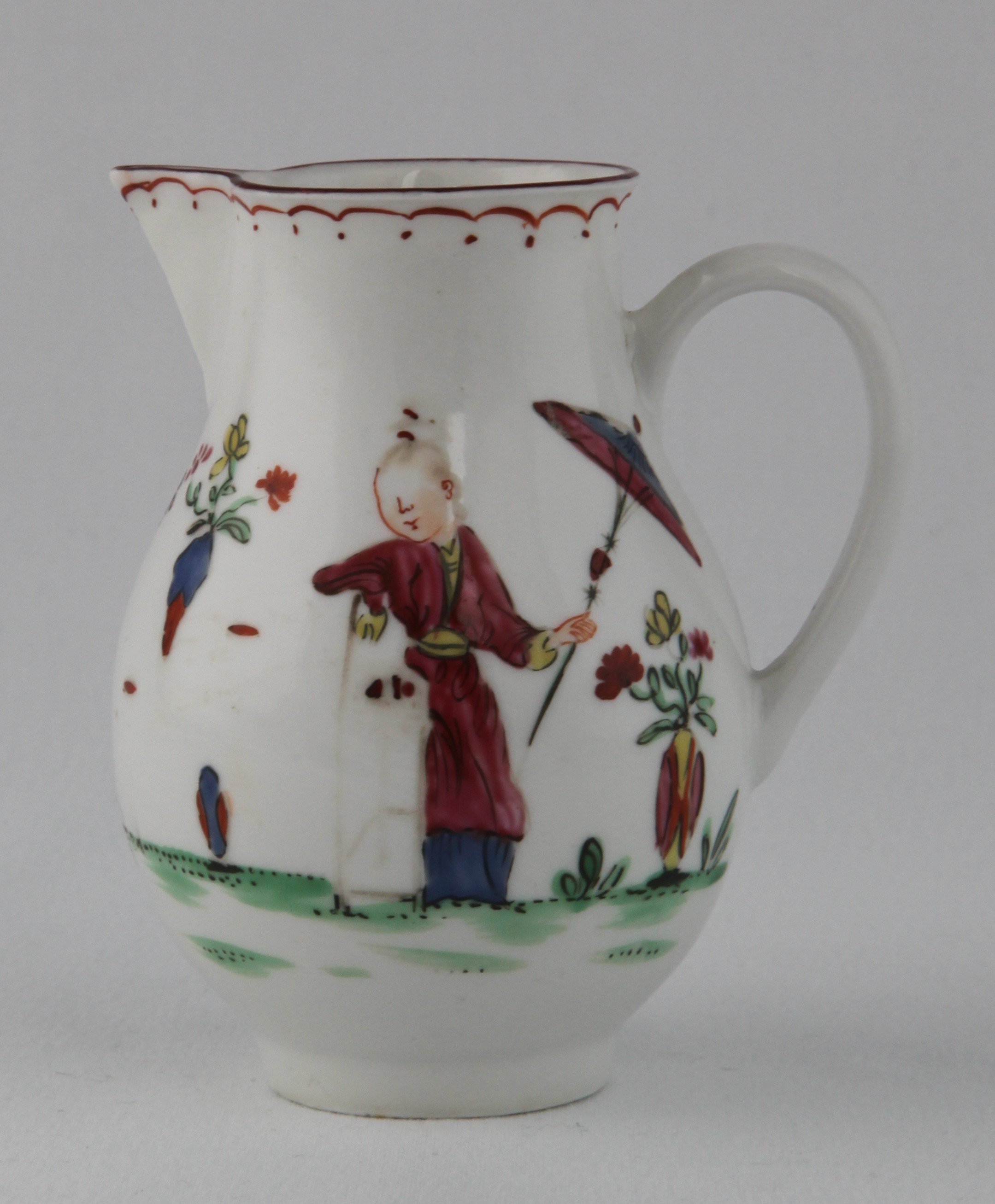 A Bristol baluster shaped sparrow beak milk jug, painted in Chinese famille rose palette with a Chinese figure with parasol, in a garden, and a boy playing a game, beneath an iron red loop and dot band, brown line rim, 3 1/2" high, circa 1775, blue painted X mark