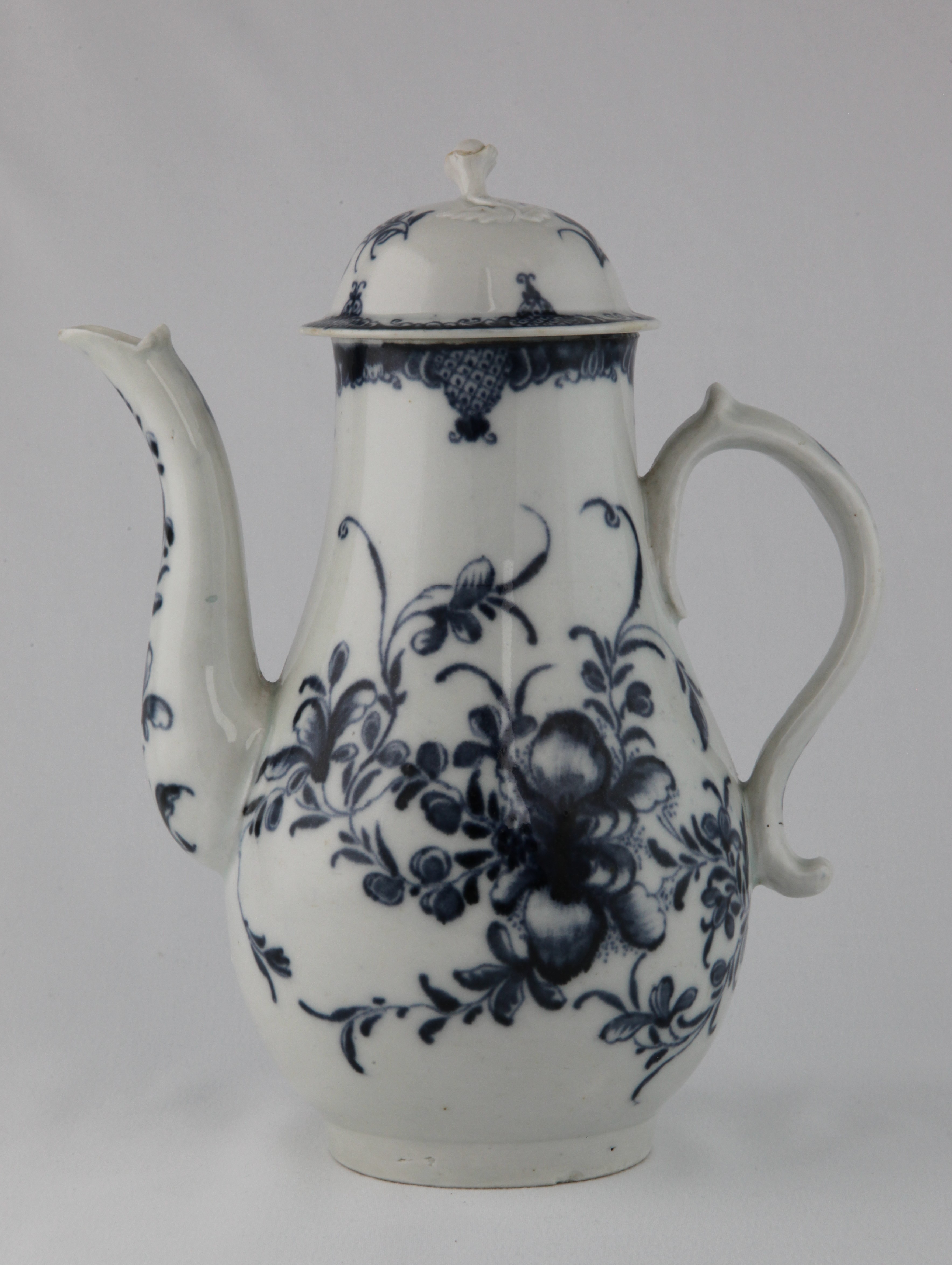 A Plymouth baluster shaped coffee pot and domed cover, with 'S' scroll handle and flower and leaf knop, painted in underglaze blue in Worcester style with the Plymouth Mansfield pattern, within diaper panelled scroll borders, 9" high, circa 1770, no mark