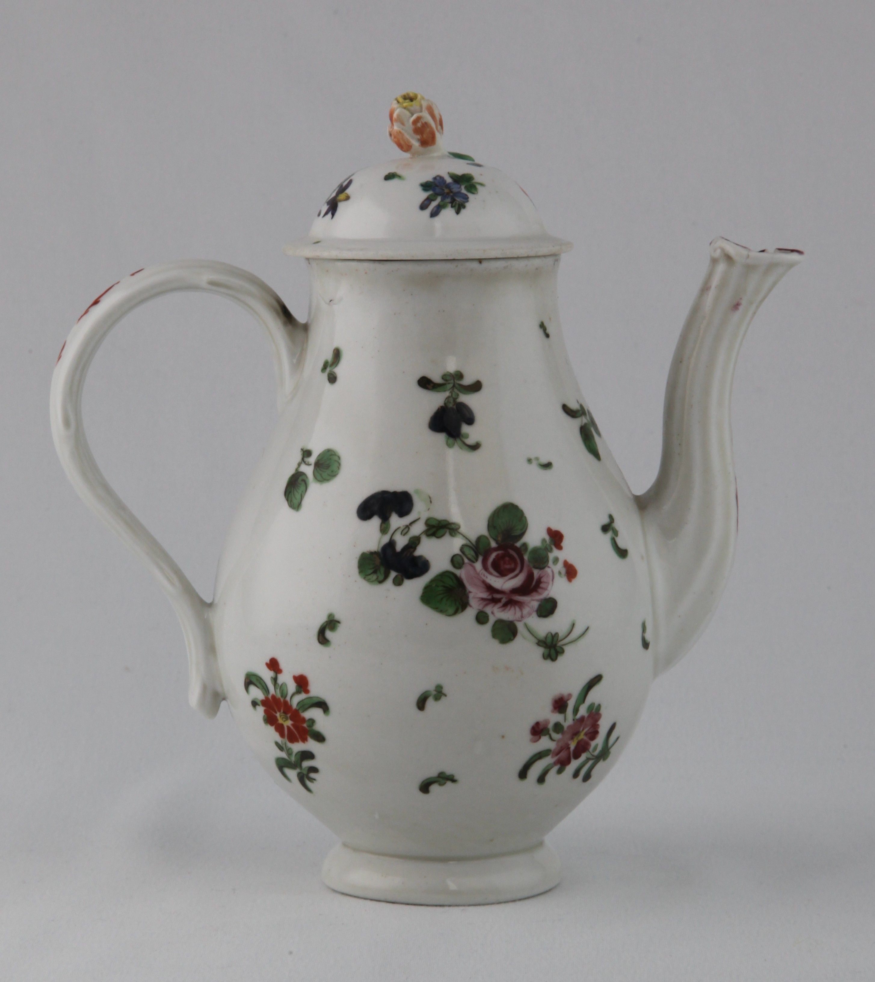 A Bristol small baluster shaped coffee pot and a domed cover, with crabstock handle, fluted spout and flower and leaf knop, painted in coloured enamels with two sprays of flowers and leaves, and scattered flowers, 6 3/4" high, circa 1772, no mark
