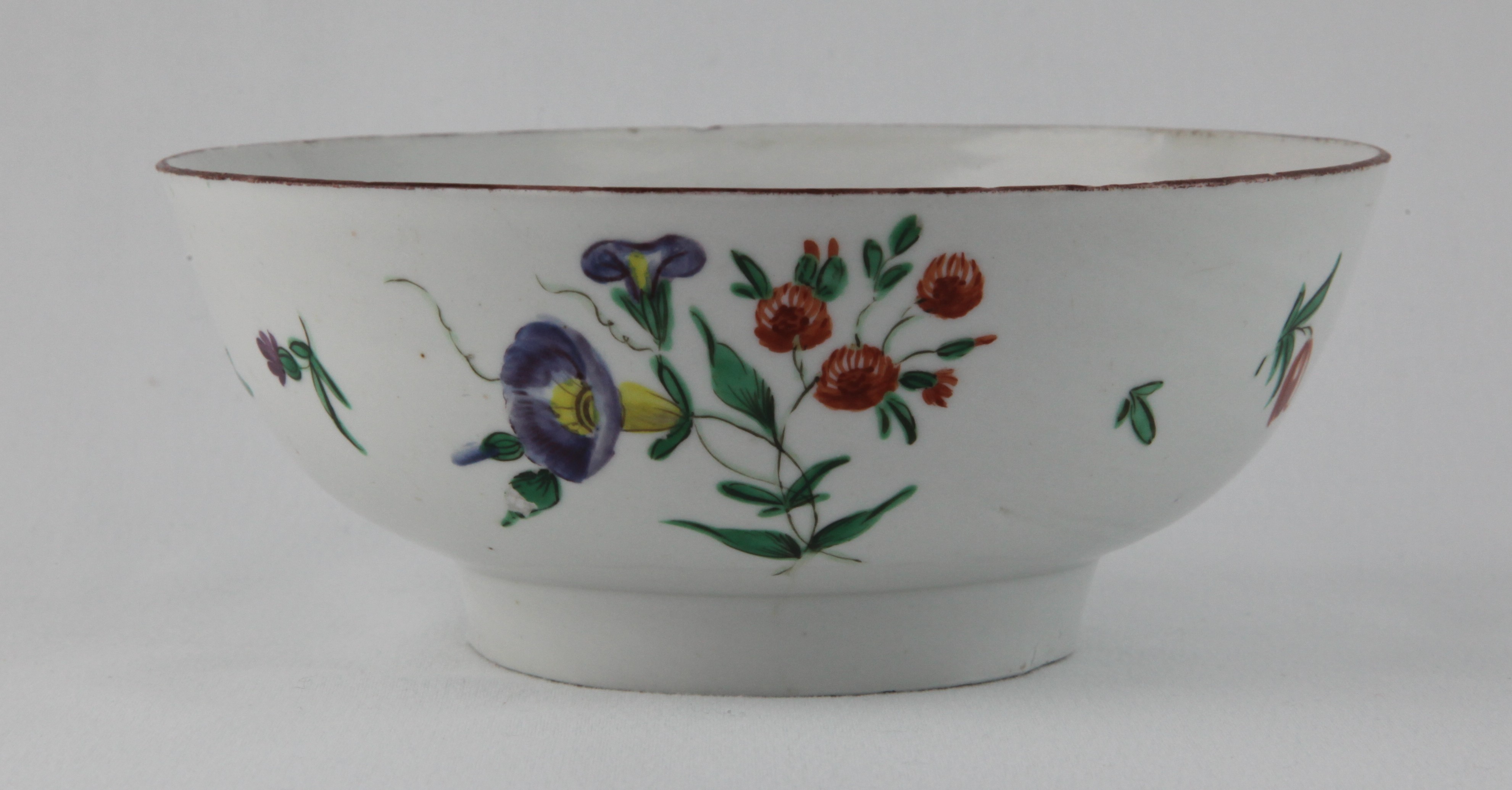 A Bristol round bowl, the exterior painted in coloured enamels with two sprays of flowers and leaves, beneath it brown line rim, 5 3/4" diameter, circa 1772, blue painted  B mark