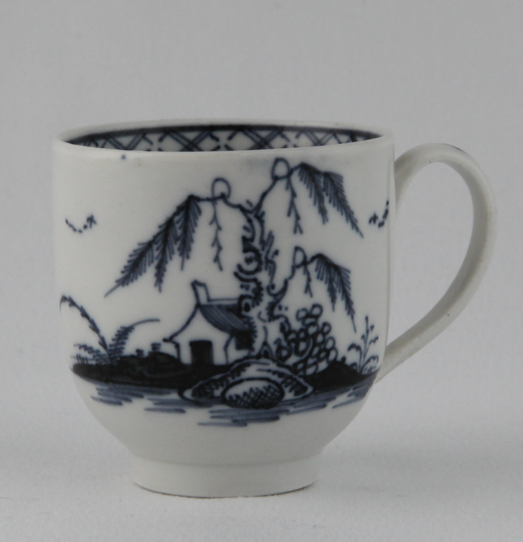 A Bristol coffee cup, with loop handle, painted in underglaze blue in Chinese style with a pavilion, a willow tree and rockwork, in a river landscape, the interior with a diaper band, 2 1/4" high, circa 1775,  blue painted X mark