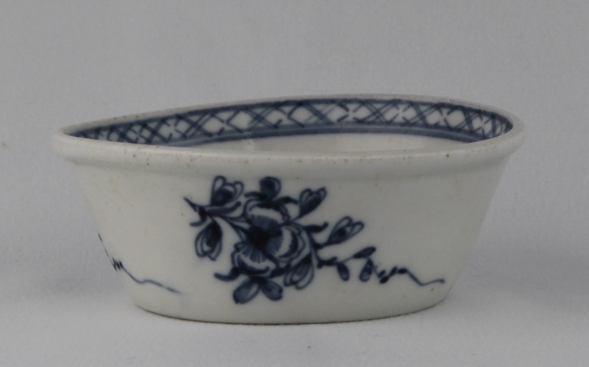 A Bristol small flared round patty pan, the exterior painted in underglaze blue with trailing sprays of flowers and leaves, the interior painted with a flower, within a diaper band, 3 1/2" diameter, circa 1775, blue painted X mark
