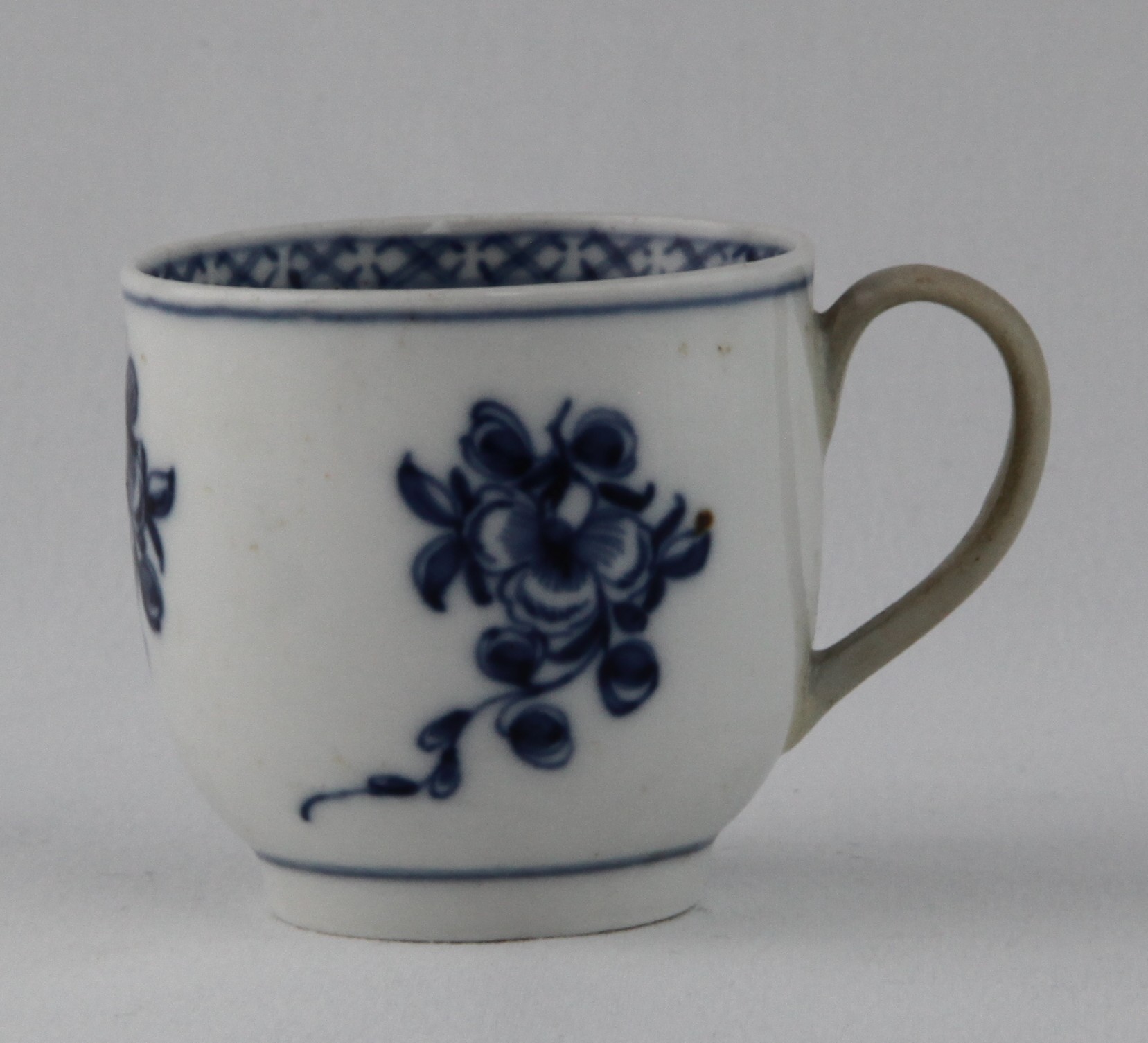 A Bristol coffee cup, with loop handle, painted in underglaze blue with three trailing flower sprays, the interior of the rim with a diaper band, 2 1/8" high, circa 1775, blue painted X mark