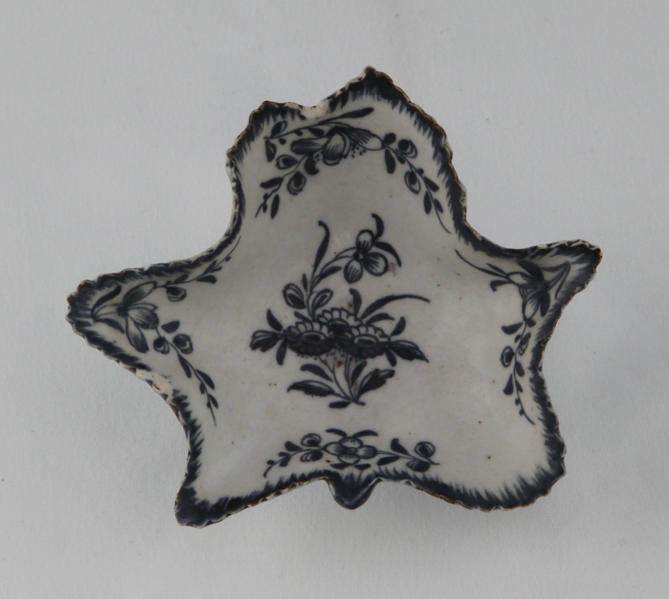 A Plymouth leaf shaped pickle dish, painted in underglaze blue with sprays of flowers and leaves, the serrated rim picked out in blue, 3 3/4" wide, circa 1770, no mark