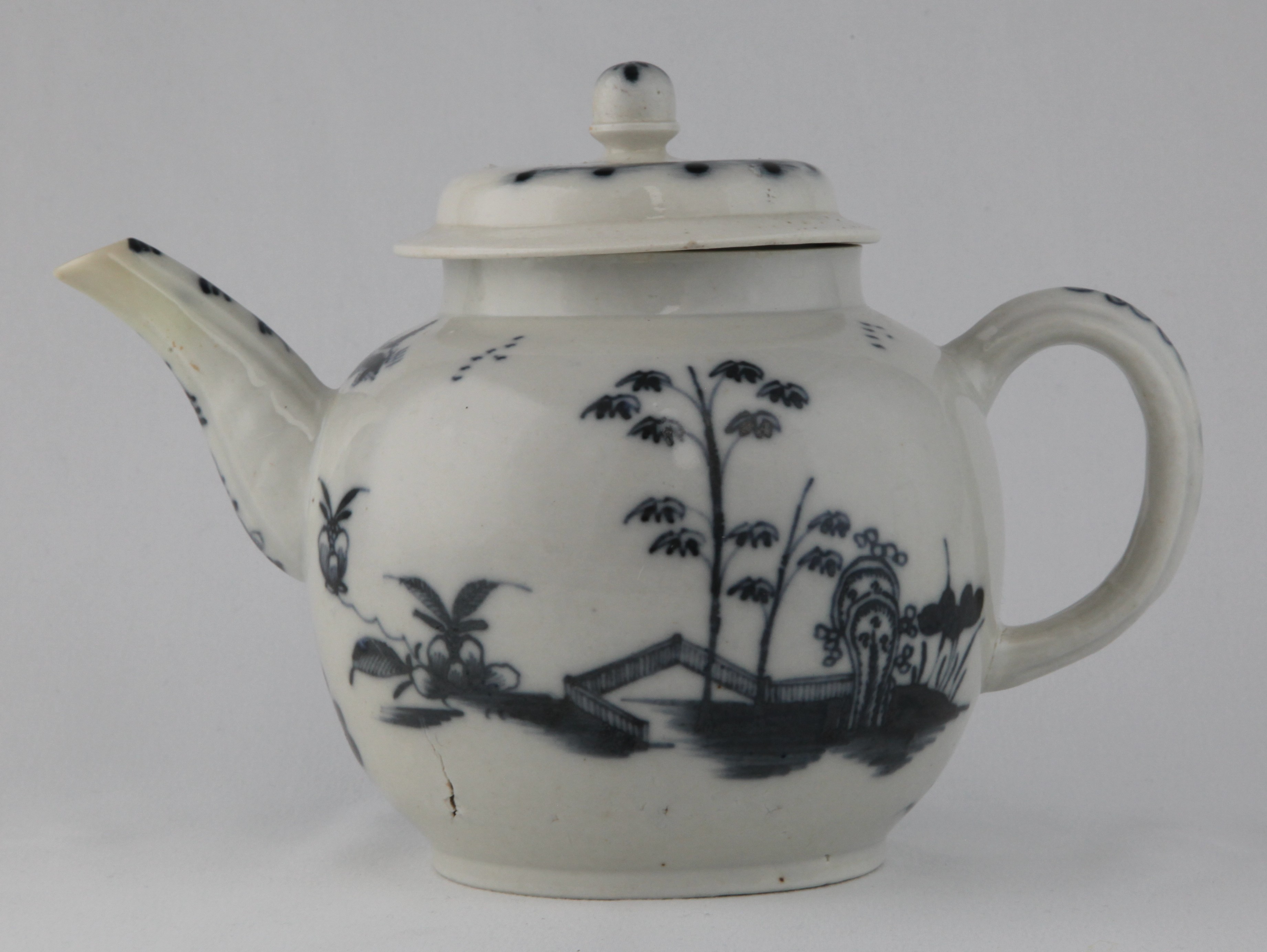 A Plymouth large globular teapot and cover, with loop handle, part fluted spout and acorn shaped knop, painted in underglaze blue in Chinese style with bamboo and rockwork in fenced gardens, with birds in flight, 6" high, circa 1770, no mark