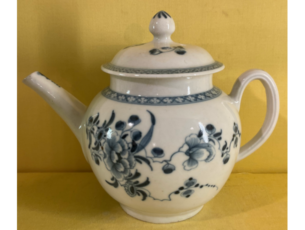 A Plymouth globular teapot and cover, with loop handle and pointed knop, painted in underglaze blue in Chinese style with trailing flowers and leaves, within diaper borders, 5 1/2" high, circa 1770, blue painted tin mark