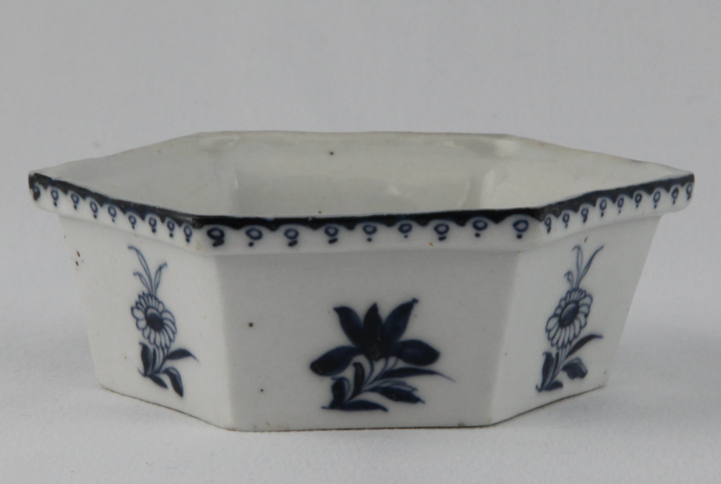 A Plymouth hexagonal centre dish, from an hors d'oeuvre set, painted in underglaze blue with flowers and leaves, beneath a loop and dot band, 4 3/8" wide, circa 1770