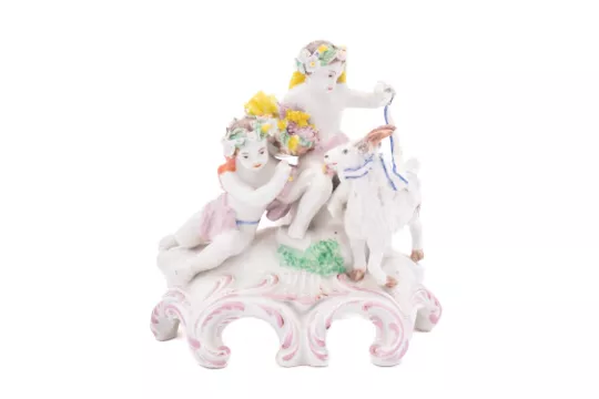 A Plymouth group of two putti with a goat the putti wearing garlands and drapery and holding a basket of grapes, one holding a blue edged ribbon to the goat's collar, on scroll moulded mound base, circa 1768-70, 15cm