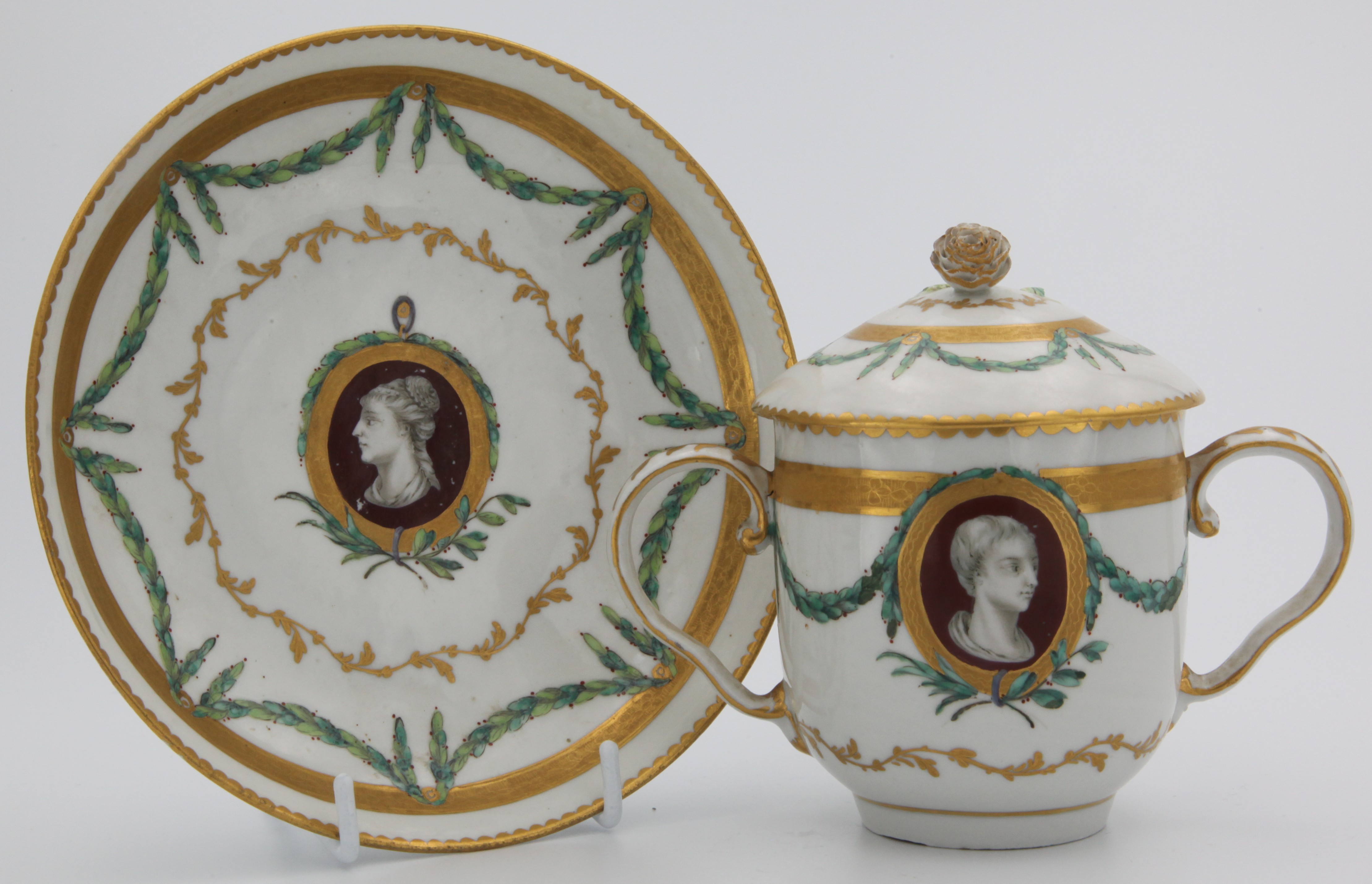 A twin-handled Bristol chocolate cup, cover and stand with cclassical portraits.