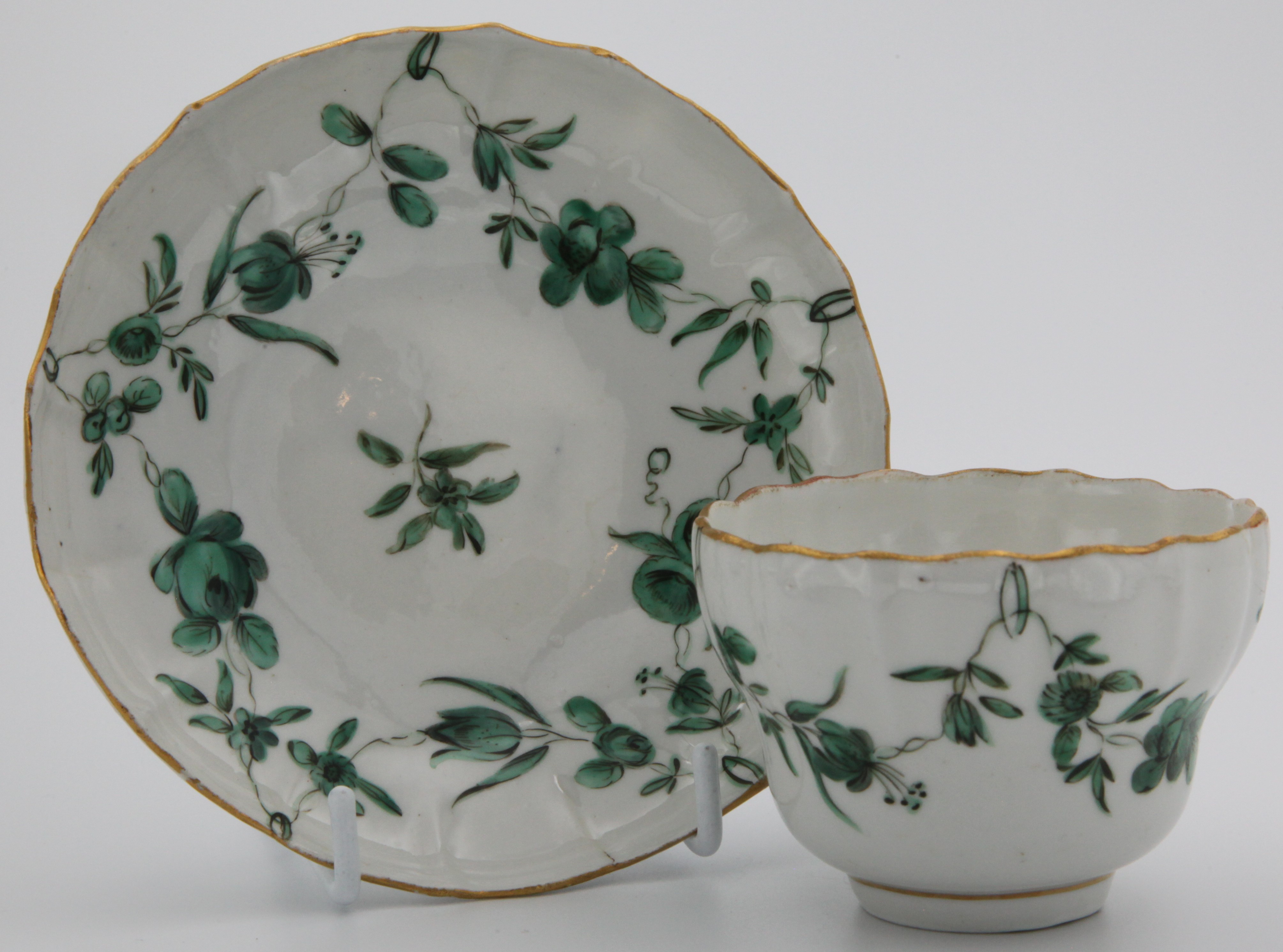 A Bristol coffee cup and saucer with green garlands suspended from green loops.
