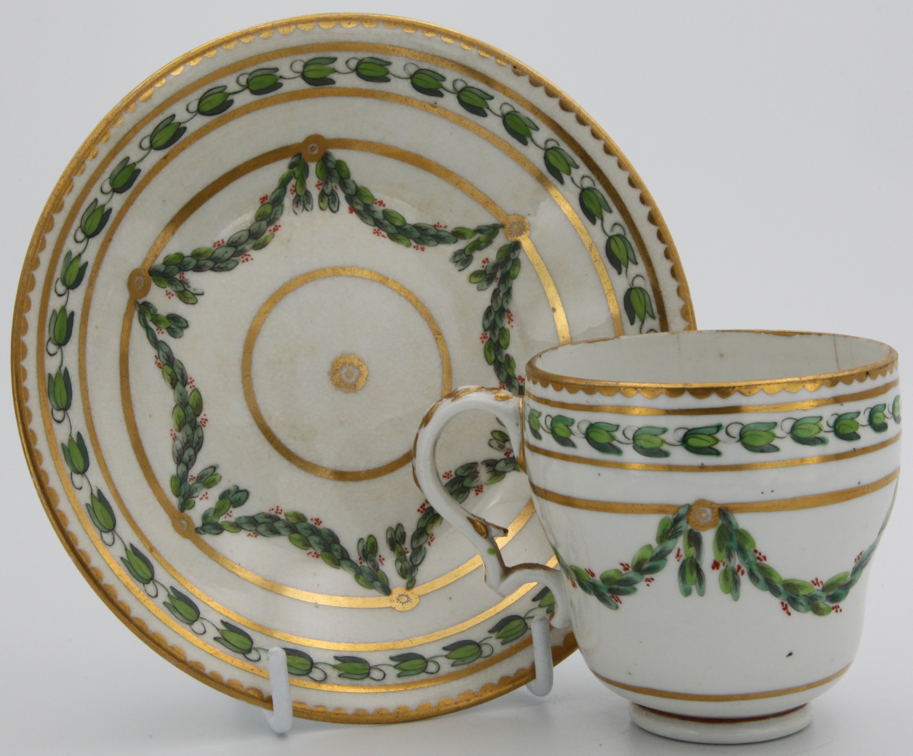 A Bristol coffee cup and saucer with laurel swags, the saucer is a later replacement.