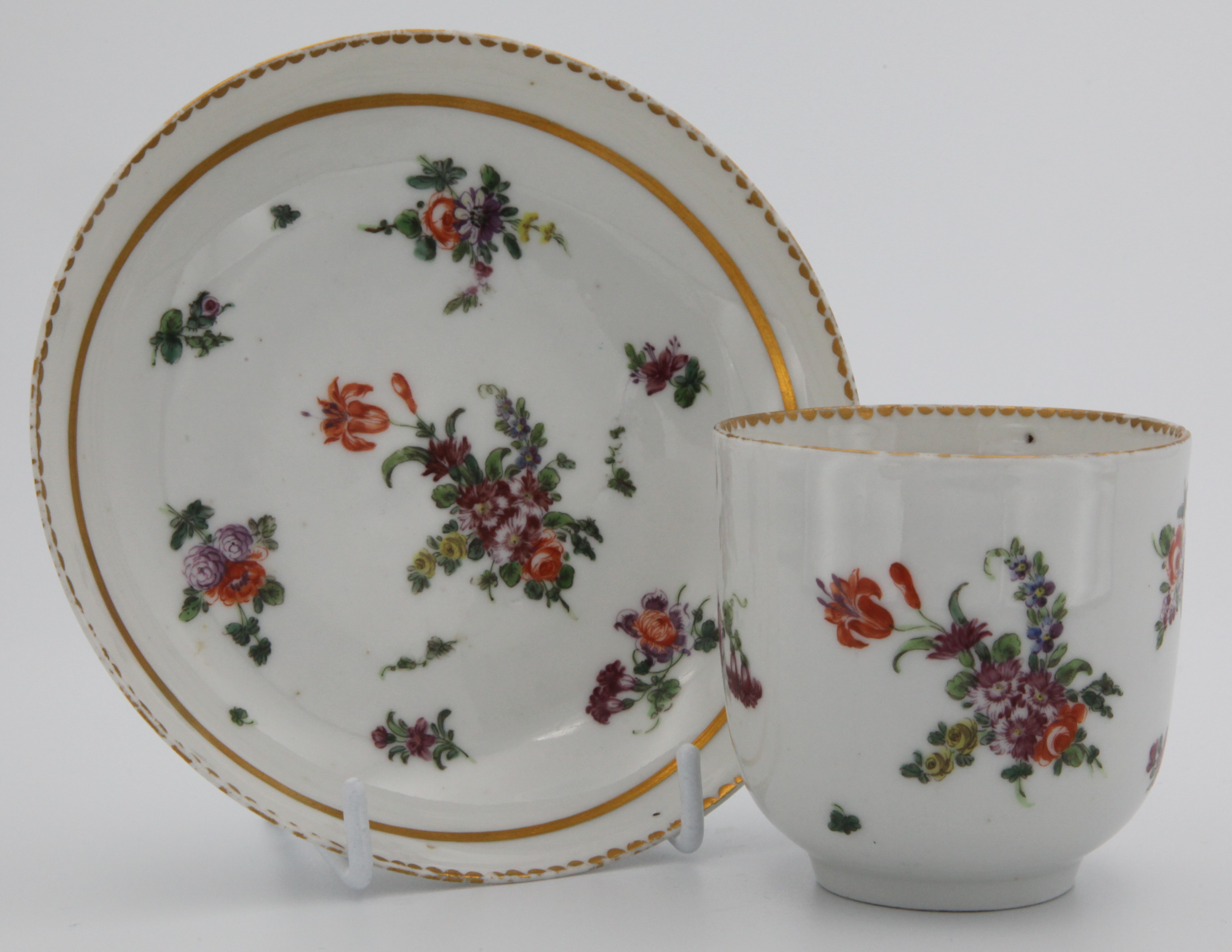 A Bristol coffee cup and saucer with central spray and two gilt borders