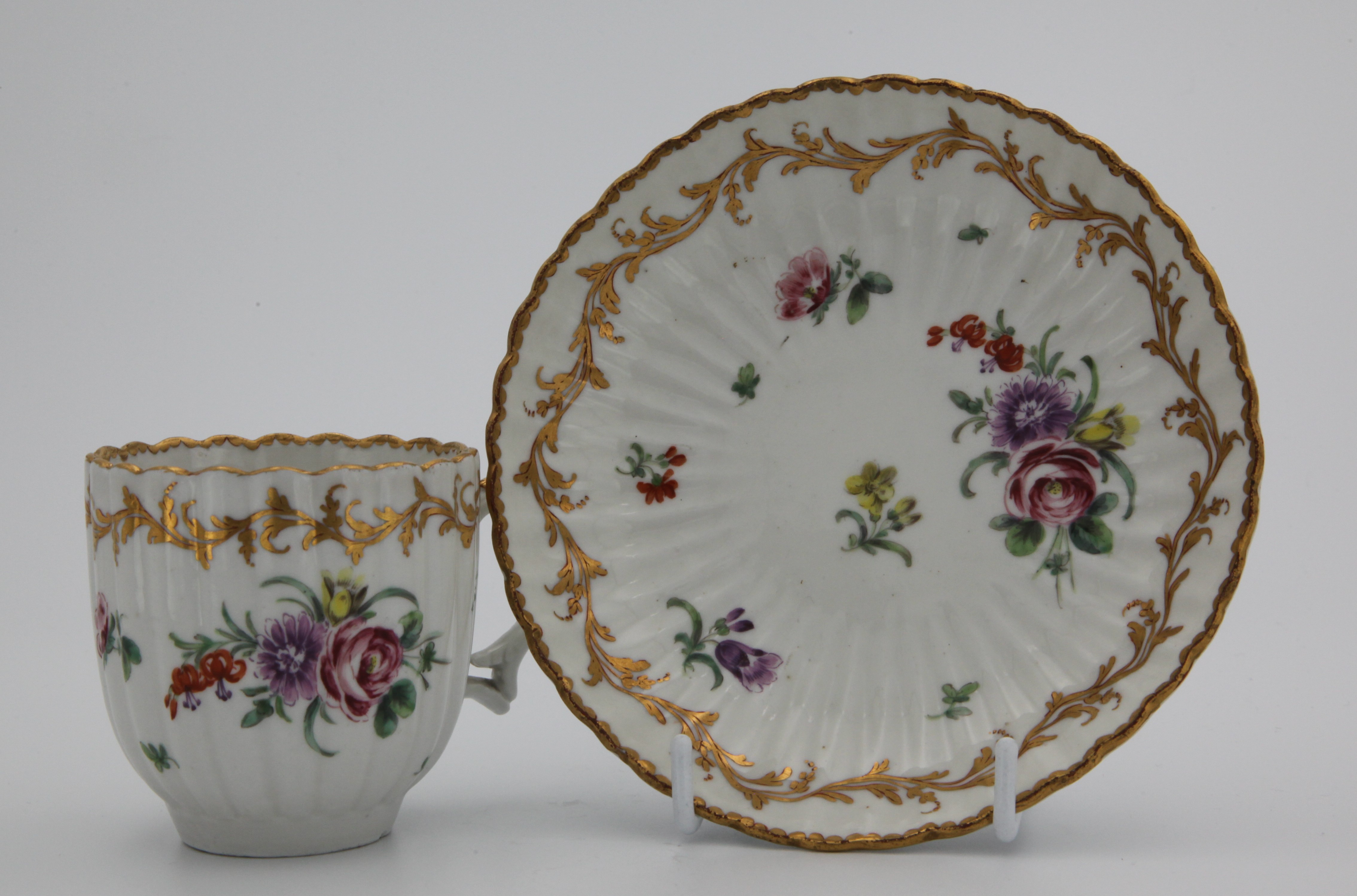 A Bristol cup and saucer with elaborate gilt decoration.